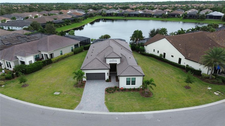 OUR LOSS IS YOUR GAIN! This custom designed home is ready for immediate occupancy. Situated on oversized lot overlooking the pond and NO view of power lines, clubhouse is just a short walk away! This beautiful 3-bedroom, 4 bath, plus den/office home with over 2,700 sq.ft of luxurious living space! The Great Room has spectacular views of the pond, custom pool with negative edge spa and upgraded Italian-style pavers, picture-view screen to allow for unobstructed views. The gourmet kitchen features designer touches of arched doorways, stacked-custom cabinets 54”, GE Monogram appliances, with gas range and feature wall of Quartz backsplash to add a dramatic touch!  The large center island with waterfall Quartz on both ends! Walk-in pantry, wet bar, and beverage refrigerator complete this space.
The primary bedroom is uniquely designed for couples wanting their own space!  Each has their own walk-in closet, toilet room, vanity is split with storage tower in between sinks (extra electrical inside cabinet), walk-in shower features spa-like shower with 2 heads and custom electronic temperature regulating feature.  Two additional bedrooms with en-suite bathrooms, offering extra comfort and privacy for family or guests. A custom “drop-zone” is located just off the garage in the upgraded Laundry Room. This room features beautiful tile floors, blue custom cabinets and accent tile backsplash. Wood floors, crown molding, accent ceilings painted and window coverings. A 3-car garage gives you that extra storage space everyone needs.