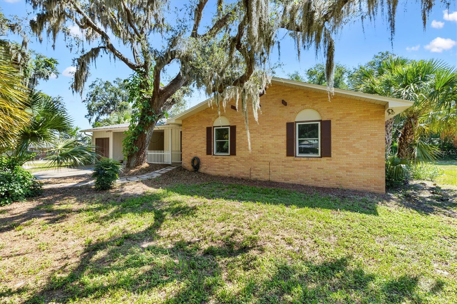 Situated on a sprawling 0.45-acre lot, this beautifully maintained 3-bedroom, 2.5-bath home combines comfort, character, and convenience. Located in the heart of Wildwood, you’ll enjoy a peaceful residential setting just minutes from shopping, dining, and The Villages. The exterior is framed by mature trees and lush landscaping, creating a serene and shaded retreat. Step inside to a bright, open living area filled with natural light and accented by gorgeous flooring. The updated kitchen showcases crisp white cabinetry, modern appliances, and a striking tile backsplash. The spacious master suite offers a private escape with an ensuite featuring a custom-tiled shower. Generously sized guest bedrooms share a well-appointed hall bath, making this home ideal for family or visitors. The enclosed porch, lined with glass windows, adds versatile living space perfect for relaxing or entertaining year-round. Outdoors, the expansive yard provides endless possibilities—from gardening and recreation to potential future additions. With its functional layout, multiple living spaces, and prime location, this home delivers both comfort and opportunity. So don't wait and call today for your private showing!