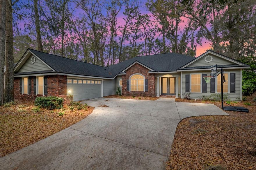 This stunning former builder’s model home by Robinshore is perfectly situated in the highly sought-after Katelyn Lane neighborhood of Haile Plantation. Thoughtfully designed and meticulously maintained, this four-bedroom, three-bathroom residence offers a well-planned two-way split layout with luxurious finishes throughout. Upon entering, soaring 10-foot ceilings and an elegant foyer lead to a formal living area featuring a cozy fireplace, while the adjacent formal dining room showcases crown molding and rich golden oak wood floors, creating a warm and inviting atmosphere. The spacious primary suite is a private retreat, offering two walk-in closets, a spa-inspired en-suite bathroom with a jetted tub, dual vanities, an expansive walk-in shower, and private access to the back patio. At the heart of the home, the gourmet kitchen has been beautifully upgraded with granite countertops, stainless steel appliances, custom wood cabinetry, and a walk-in pantry. A charming breakfast nook provides the perfect spot for casual dining, flowing effortlessly into the expansive family room, which is ideal for both relaxation and entertaining. On the opposite side of the home, two generously sized guest bedrooms share a well-appointed full bathroom, ensuring comfort and privacy. A fourth bedroom, located near the entrance with an additional full bathroom, is perfect for a home office, featuring classic brick flooring that adds timeless character. Step outside to a large screened porch overlooking a serene backyard with no direct rear neighbors, backing onto a private common area for added tranquility. The outdoor concrete patio, complete with a fire pit, creates an ideal setting for entertaining under the Florida sky. Enhanced landscaping in the front yard adds to the home’s impressive curb appeal. Additional highlights include an oversized two-car garage, fully re-plumbed (2025), a roof installed in 2019, Plantation Shutters, a GEO security system, and an oversized laundry room complete with a wine fridge and a new washer and dryer (2021). A transferable home warranty through Choice Home Warranty is included until December 2027, offering peace of mind. With an unbeatable location just 60 yards from Lawton Chiles Elementary School, one of Alachua County’s top-rated schools, this home offers both convenience and prestige. Residents of Haile Plantation enjoy access to scenic biking and walking trails, a vibrant farmers market in Haile Village Center, and a convenient Publix at Haile Market Square. Optional memberships are available for the community’s golf course, pool, tennis courts, and clubhouse, enhancing the resort-style lifestyle. A rare find in one of Gainesville’s most desirable communities, this home blends luxury, functionality, and an unbeatable location. Schedule your private showing today!