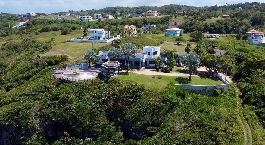 Welcome to “Pearls of the Sea” – Your Oceanfront Sanctuary
Perched atop a dramatic cliffside with panoramic views of the Atlantic Ocean, Pearls of the Sea is a rare and extraordinary opportunity to own a slice of paradise. Spanning 2 private acres across four separate parcels, this unique property offers limitless potential to create your ultimate dream estate.
The existing 4,138 sq ft residence features 5 generously sized bedrooms—all with soaring double-height ceilings—offering a light-filled, open feel throughout. With 3.5 bathrooms, including a luxurious master suite complete with a spa-style ensuite, the home effortlessly blends comfort and elegance.
Outside, enjoy resort-style living with a sparkling pool, charming gazebo, and a private basketball court—ideal for entertaining and unwinding under the sun. A spacious 3-car garage with ample storage ensures convenience for everyday living or future expansion.
Included in the sale are two full sets of architectural plans and approved building permits, giving you a head start on transforming this already-stunning setting into a bespoke luxury estate. Envision an infinity-edge pool, an open-concept outdoor kitchen, and grand living spaces designed to showcase the breathtaking seascape at every turn.
With direct access to captivating coastal caves and rock formations, this one-of-a-kind property is more than just oceanfront—it’s ocean-immersed. Every window, every room, and every detail is an invitation to wake up to the sound of the waves and live in harmony with the raw beauty of the Caribbean coastline.
Whether you’re drawn by the privacy, the potential, or the pure natural splendor, Pearls of the Sea is your canvas to create an iconic legacy estate. Don’t miss this once-in-a-lifetime opportunity to own where the sea meets the sky. Contact us today to schedule a private tour. Owner financing Available.