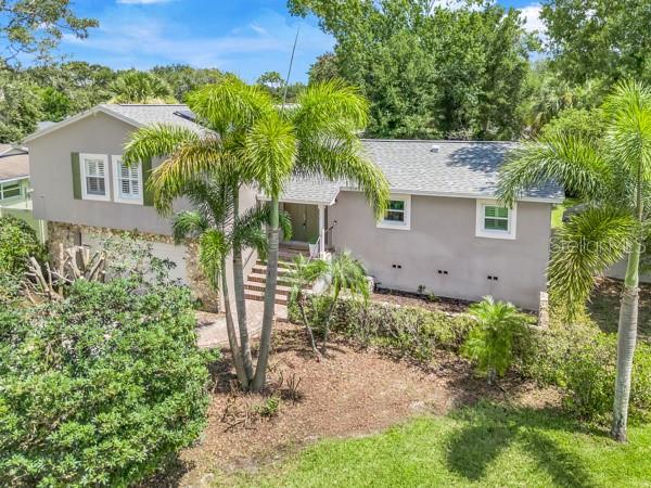 WELCOME HOME to 8251 Tansy Drive, where space, character, and OPPORTUNITY come together in the highly sought after Dr. Phillips community of Sand Lake Hills! This distinctive, multilevel 4 Bedroom, 3 Bath POOL home + (5th) BONUS ROOM is situated just under a half acre on a spacious corner lot surrounded by mature trees and lush landscaping. Its unique layout, flexible living areas, and standout features offer a level of versatility rarely found in today’s market. Inside, charm and comfort are found at every turn. Double pane windows throughout the home fill the space with beautiful natural light, while plantation shutters and thick crown molding add a timeless, elegant touch. The living area is warm and welcoming, flowing seamlessly into a well-appointed kitchen with stainless steel appliances, granite countertops and a flex space that connects to the dining area perfect for all types of gatherings. At the upper level, the primary suite provides a generous space, complete with a stylish en-suite bathroom featuring a bidet system, double vanity, walk in shower, and large linen closet. Heading down the corridor you will find another full bathroom along with three additional generously sized bedrooms, providing space and privacy for everyone. The lower level of the home presents incredible flexibility. Here you will find a third bathroom bordering an expansive and private bonus (5th) room which features its own separate entrance leading directly to the fenced in backyard and pool area. This valuable space is ideal as an office, media room, creative studio or playroom. Even better - it could easily transition into an IN-LAW SUITE, thanks to its connection to the laundry room which could be converted into a kitchenette to unlock additional potential for multi-generational living or rental income. Major updates offer both peace of mind and increased value, including a BRAND-NEW ROOF (2024), SLIDING GLASS DOORS AND DECK (2024) UPGRADED HVAC SYSTEM (2016), DOUBLE-PANE WINDOWS (2020), and a PREMIUM SOLAR PANEL SYSTEM installed in (2023) valued at over $50,000 to be FULLY PAID OFF by the Seller at closing. This system provides enough capacity to support future additions plus ZERO ELECTRICITY BILLS saving you hundreds towards your monthly budget. Located just minutes from Orlando’s Restaurant Row, top-rated Dr. Phillips schools, upscale shopping, and major highways and attractions, this home truly offers the best of convenience and lifestyle. Whether you're searching for a forever home , multi-generational space, or a smart investment opportunity, this distinctive home is a rare find in one of Orlando’s most desirable communities.