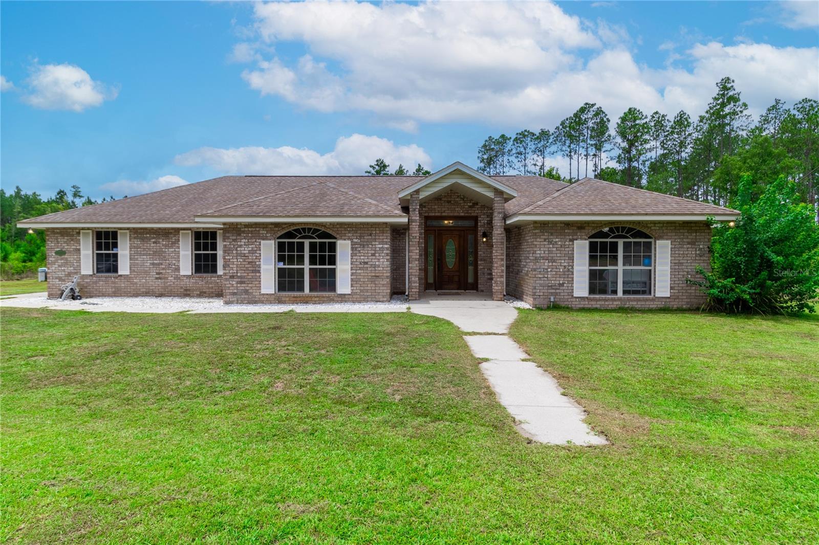 Welcome to your dream retreat! Nestled on 5 serene acres in the heart of Lake Butler, this beautifully maintained 3 bedroom, 2.5 bath home offers the perfect balance of comfort, space and Florida charm. It has the ideal layout which includes split bedrooms with en suite convenience. The spacious primary suite includes split vanities, walk in closet, walk in shower and tub. This private paradise also has two fireplaces for coziness and elegant ambiance. One fireplace is in the family room and the other in the primary suite. Step outside and be wowed by the large screened patio that opens up to a gorgeous in-ground pool-a perfect place to unwind after a long day or host weekend get-togethers. This property offers ample space for outbuildings, a barn, or a beautiful garden, and there's plenty of room for boats, RVs, or recreational vehicles.