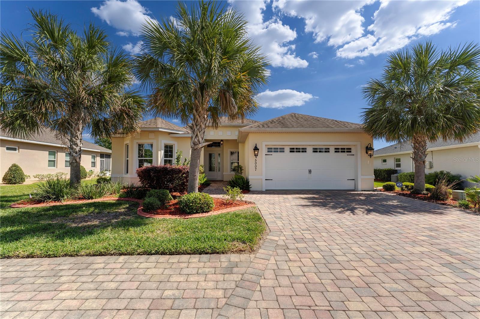 This stunning custom-designed home is a true showstopper, offering luxurious upgrades and an unbeatable resort-style lifestyle. Situated on a beautifully landscaped lot with several palm trees and concrete-curbed planting beds, this property welcomes you with incredible curb appeal. Inside, you'll find a spacious and thoughtfully designed open-concept layout, featuring three bright and airy bedrooms, two full baths, and a versatile bonus room—perfect for a home office. The primary bedroom is generously sized, offering two walk-in closets and an elegant en-suite bath with a large walk-in shower, double-sink vanity, and abundant storage. The additional guest bedrooms are equally spacious and inviting. The well-appointed kitchen is a chef’s dream, boasting sleek Quartz countertops, ample counter space, and modern finishes. Adjacent to the kitchen, the living and dining areas flow seamlessly, making this home perfect for entertaining. Step outside to the impressive 12x28 lanai, where herringbone-patterned porcelain tile, stylish ceiling fans, and roll-down privacy shades create a perfect space to unwind with a cocktail or a good book. This home is loaded with premium upgrades, including 24x24 ceramic and porcelain tile flooring throughout—no carpet! Beyond the home itself, the neighborhood offers an unparalleled resort lifestyle. Lakeside Landing offers a beautiful clubhouse, fitness center, billiards room, and a breathtaking 200,000-gallon pool with waterfalls. Enjoy pickleball and tennis courts, as well as exclusive access to Lake Miona. Plus, you're just a quick 2-mile ride in a street-legal golf cart to Sumter Landing! Additional amenities include lawn maintenance, mulching, pest control, irrigation, and trash pickup—giving you a worry-free, luxurious living experience. Don't miss your chance to own this extraordinary home in an unbeatable location!