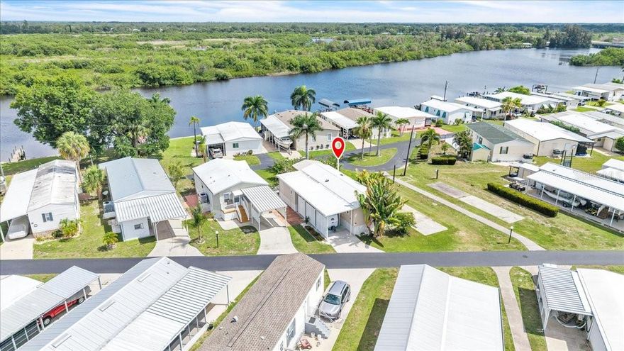 Welcome to the waterfront community of Lazy Lagoon in Punta Gorda! This charming custom site-built home offers 1 bedroom, 2 bathrooms +versatile den. Enjoy the relaxed coastal lifestyle with community amenities just steps away—fish from the community-owned dock on Shell Creek or unwind beneath the shade of majestic live oaks in the beautifully maintained waterfront park adjacent to your deck. The open-concept living and kitchen area features a spacious layout filled with natural light and coastal charm. The kitchen showcases a functional U-shaped design with abundant counter space and eye-catching turquoise cabinetry. Neutral countertops & white appliances create a clean and cohesive aesthetic. Built-in shelving, additional cabinetry, and a generous walk-in pantry provide exceptional storage and convenience. Bamboo wood flooring flows throughout the home while raised vaulted ceilings create an airy, open feel. Tropical-inspired paint colors, skylights, and ceiling fans further enhance the bright and breezy atmosphere. Bluetooth-ready built-in ceiling speakers allow you to enjoy music throughout the home. Energy-efficient upgrades include hurricane-resistant insulated siding, heat-reflective sub-roofing, and a 2017 AMS Weather-Lok aluminum roof-over system offering outstanding durability, energy efficiency, and a lifetime transferable warranty. The primary bedroom features a generous closet, hidden cabinetry for golf clubs/gear, and a skylit ensuite bath complete with a tub/shower combo, integrated laundry area and additional concealed storage. The den offers exceptional flexibility as a guest room, home office, or additional living space. Its full bath includes a freestanding single-sink vanity and a relaxing deep soaking tub, complemented by a dedicated tankless water heater to ensure endless hot water for a spa-like experience. Step outside through sliding glass doors with privacy blinds onto the beautifully designed 16x12 covered deck.  This elevated outdoor living space features durable low-maintenance decking, generous room for seating and dining, and a large overhead canopy providing shade and weather protection. The deck is surrounded by mature seagrape trees and lush native landscaping, while an outdoor ceiling fan keeps the space cool and comfortable. Beneath the deck, a built-in “boat house” conveniently stores two included Hurricane Santee 126 kayaks with paddles. Additional features include a covered carport with new shade lattice and native landscaping, Bahama-style hurricane-rated storm shutters, aluminum hurricane-rated panels for the sliding doors, clear hurricane-rated panels for the bathrooms and kitchen, Eemax tankless water heater (2020), upgraded plumbing fixtures, and 12 "SmartJack" support posts designed to help prevent settling and reduce the need for periodic releveling. Residents of Lazy Lagoon enjoy a variety of amenities tailored to an active Florida lifestyle, including a private boat ramp with direct access to Shell Creek, over 2,000 feet of maintained waterfront shoreline, shuffleboard courts, billiards room, and a spacious clubhouse with a commercial kitchen hosting regular social events. A secure storage compound for boats and trailers is also available for a nominal annual fee. Conveniently located just minutes from Punta Gorda, this exceptional waterfront home offers easy access to boating, waterfront dining, shopping, parks, entertainment, and all the best that Southwest Florida has to offer.