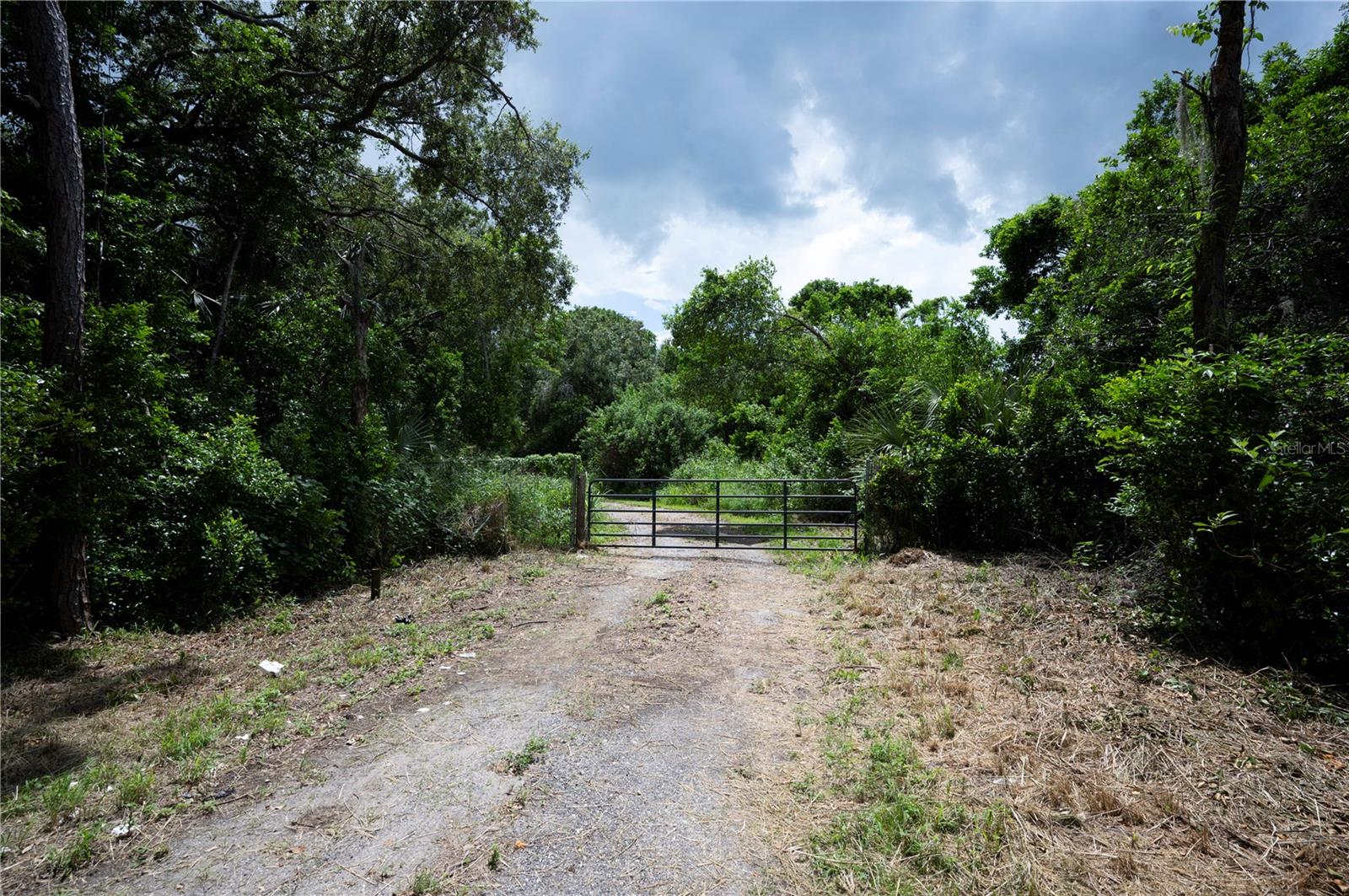 The property you are inquiring about is located in Winter Haven, FL in the Overlook Dr SE area of Polk County. This is 4.37 acres of improved land that has beautiful trees, pond with island, partially fenced, 2-story barn, covered RV parking space, septic system in place to accommodate an additional structure, well house to include pump, bladder tank and electrical panel, 400 Amp beneath ground service, back flow switch for generator to power well if necessary. And then, the Barn-dominium has 1,728 square feet, water, electric, and all concrete slak - Now do not underestimate the value on the access of this acreage. *Agents, please read MLS remarks.*