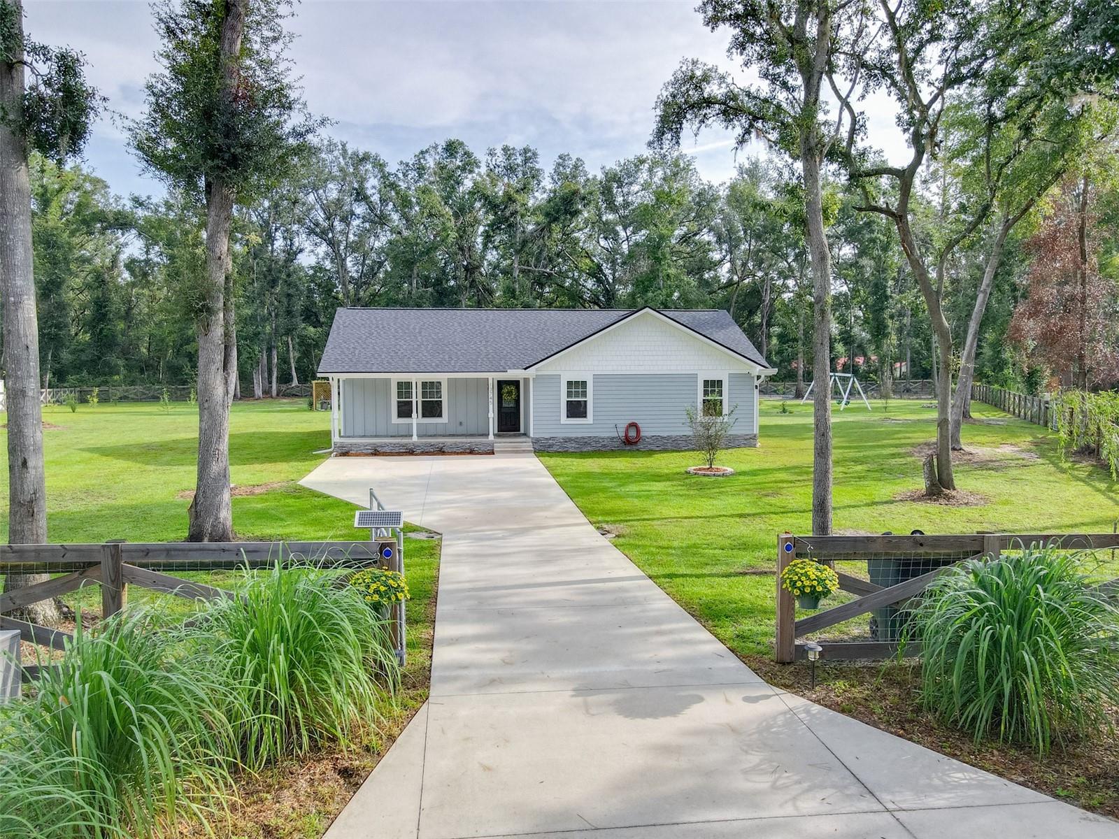 Located in the highly desirable Greenbriar neighborhood of Live Oak, this 2022-built 3-bedroom, 2-bathroom home sits on a cleared, fully fenced 1.14-acre cul-de-sac lot, offering the perfect blend of modern comfort, privacy, and rural functionality.
Enjoy a warm welcome through the powered automatic front gate, framed by a beautiful cross-buck style perimeter fence, with a secondary access gate for added convenience. Inside, you’ll find a bright, open-concept layout with granite countertops, like-new appliances, and modern finishes throughout. With 1,516 square feet, this home offers just the right balance of space, functionality, and efficiency. Step outside to a homestead-ready oasis featuring:
• Multiple producing fruit trees
• A custom-built chicken coop with fenced free-range area
• A 20’x20’ metal building with roll-up garage door and 100-amp sub panel
• Whole-house hydrogen peroxide water purification system, delivering premium drinking-quality water to every faucet in the home.
Location is ideal: just minutes from the hospital, Publix, Chick-fil-A, and other major shopping and dining destinations.
This is a rare opportunity to own a newer home with acreage, fencing, modern amenities, and room to grow.
Schedule your private showing today!