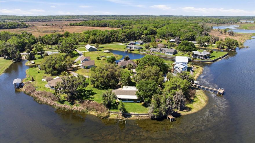 Enjoy lakefront living in this well maintained home situated directly on Orange Lake in the Orange Lake Shores community of Micanopy. Set on an oversized 0.63 acre lot, this property offers space, natural beauty, and direct access to the water. This 2 bedroom, 3 bathroom home features an open floor plan designed for comfortable living and entertaining. The spacious kitchen flows into the main living areas, while a large Florida room with a wall of windows showcases expansive lake views and brings in abundant natural light. Built-in storage throughout adds to the functionality and organization. Outdoor features include a screened in patio, mature landscaping with beautiful oak trees, and a private wood dock—ideal for enjoying the waterfront setting. The property offers ample parking and storage with an attached 2-car garage, an additional attached carport with space for two vehicles, and a garage area that includes built-in cabinets, a workshop space, and a laundry room. Located in a quiet setting with convenient access to nearby amenities, this Orange Lake property provides an opportunity to enjoy waterfront living with space and versatility.
