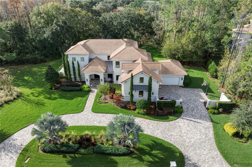 Experience the ultimate in luxury living in this magnificent residence located in Avila, Tampa Bay's premier guard-gated, golf, and country community. Built in 2019 by Campagna Homes, this custom-designed estate boasts 5,301 square feet of air-conditioned living space, 5 Bedrooms, 5 full and 1 Half Bathrooms, Bonus Room, Home Office,  4-car garage, and a breathtaking Swimming Pool and Spa. The  meticulously landscaped grounds accentuate the architectural splendor of the home where you will also enjoy the unparalleled privacy on this 0.9 acre homesite. As you enter through the double front doors, you'll be captivated by the grandeur of the beautiful great room which includes 22-foot high ceilings, a coffered ceiling, Restoration Hardware Chandeliers, and a linear fireplace with a brick accent wall.  The open floor plan seamlessly connects the dining room to the kitchen and the great room, creating an ideal setting for entertaining. The gourmet kitchen is a chef's dream, equipped with Thermador appliances, including a 6-burner gas range and double ovens. The kitchen island provides additional seating, and the adjoining kitchen dining room is perfect for informal gatherings. Adjacent to the kitchen is a guest bedroom with a Murphy bed which is currently used as a playroom and includes a full bathroom. The first-floor owner's suite serves as a sanctuary, featuring a spa-like bathroom and a spacious walk-in closet. The owner's bathroom boasts marble floors, a freestanding tub, frameless glass walk-in shower with a rain shower-head, marble tile accent walls, a water closet, and his/her vanities with granite countertops. The first floor is complete with a home office and a powder bathroom. Upstairs, you will find three ensuite bedrooms and a bonus room that can be utilized as an additional bedroom if needed. The outdoor living space is beyond compare and incudes a beautiful screened in swimming pool, spa, an outdoor kitchen, tongue & groove wood ceiling and temperature controlled fans.  You will truly love your outdoor oasis with plenty of covered space to relax and dine.  Immerse yourself in breathtaking luxury and privacy in this magnificent residence, while enjoying the security and privacy of living in Tampa Bay's premier golf and country club community, Avila.
