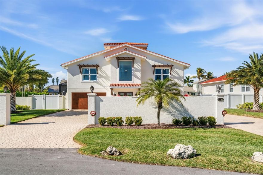 Experience refined waterfront living in this thoughtfully updated, move-in-ready residence sold furnished, ideally located West of the Trail, just minutes from shopping, dining, and the world-renowned Siesta Key Beach. Positioned at the end of a quiet cul-de-sac and only two lots from open bay, this property offers sweeping water views and sunset backdrops. The interior is filled with natural light, with impact-rated windows and sliding glass doors throughout the residence. Neutral coastal finishes including whitewashed oak flooring, porcelain tile, custom cabinetry, and a striking steel-and-cable stair railing creates a modern yet timeless aesthetic throughout the home. The kitchen serves as the heart of the home, featuring quartz countertops, gas range, an oversized island, and a custom stainless steel and glass hood perfectly suited for everyday living and entertaining. Adjacent living and dining spaces are anchored by a stacked-stone gas fireplace and open directly to a waterfront terrace. The main living area includes a primary suite along with two additional bedrooms and baths, all conveniently accessible by both a staircase and two-stop elevator. A third-floor loft offers flexible living or guest accommodations, complete with a wet bar and an expansive deck. The ground level provides a generous bonus space, dual two-car garages, and the perfect outdoor retreat featuring a summer kitchen, pool, and fire pit. Recent upgrades include new pool equipment, refreshed landscaping and fencing and a renovated dock equipped with a 20,000-lb boat lift. An exceptional waterfront setting and desirable location makes this residence a rare opportunity to enjoy the best of coastal living in Sarasota.