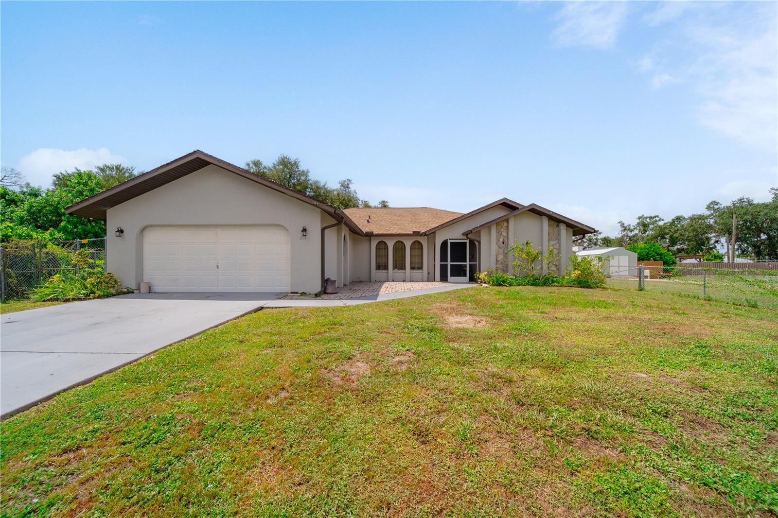 Welcome to your future dream home! This beautifully updated residence offers over 2,000 sq. ft. of comfortable living space with 3 bedrooms, 2 bathrooms, and a 2-car garage. A brand-new roof will be installed, giving you peace of mind for years to come—just move in and start enjoying. Inside, the spacious master suite features two walk-in closets and a remodeled bathroom with an expanded tiled shower, a Jacuzzi tub, and a double vanity with epoxy countertops and sinks. Recent upgrades throughout the home include luxury vinyl plank flooring in every room, a new porcelain kitchen sink, updated countertops, modern lighting fixtures, and a refreshed guest bathroom with a new vanity. The open layout flows seamlessly to the screened lanai, accessible through pocketing sliding glass doors from both the living room and great room—perfect for indoor-outdoor living or future pool plans. Out back, the fenced yard includes a 10x17 storage shed with double doors and a ramp for easy access. The home also features a screened front entry with double doors, making every entrance inviting. With so many recent upgrades and thoughtful touches, this home truly has it all. Come see it in person—you won’t be disappointed!
