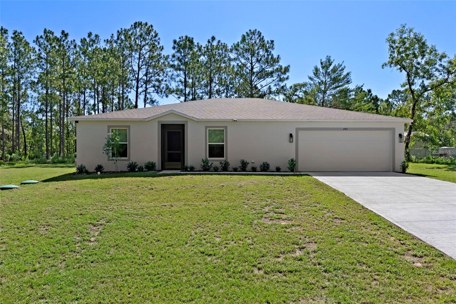 Discover this beautifully enhanced nearly new, light and bright, 4-bedroom, 2-bath, 2-car garage home situated on a nearly .50-acre lot in desirable Citrus Springs, FL. Thoughtfully updated and expanded, this home blends comfort, functionality, and style—perfect for modern living and located at the end of a cul-de-sac for added privacy. Step inside this 6 month new home to find a sprawling 22' x 36' living room, created by removing a fifth bedroom to maximize open-concept living space. The upgraded kitchen features granite counters and additional cabinetry with new hardware, a walk-in pantry with a stylish barn door, and a large laundry room with extra storage. Throughout the home, you’ll appreciate upgraded door hardware, ceiling fans in every room, and tasteful window coverings. The primary bathroom has been customized with a luxurious expanded shower, while quad 10-foot sliding glass doors flood the main living area with natural light and open onto a large 20' x 27' screened patio with birdcage enclosure—ideal for entertaining or enjoying Florida’s beautiful weather. The screened front entry adds an inviting touch and enhances airflow. Practical upgrades include six security cameras for peace of mind, a high-end well-water filtration system, upper power outlets ready for wall-mounted TVs, a sealed and epoxy-coated garage floor, and new carriage-style garage lights. With no HOA or CDD fees, you’ll enjoy the freedom to live how you want—bring your toys, RVs, or boats with no restrictions. This move-in-ready home offers space, privacy, and peace of mind in a community that values independence. Schedule your private showing today and come experience all that Citrus Springs living has to offer!