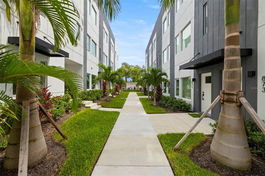 Live the vibrant urban lifestyle in this stylish and spacious 2-bedroom, 2.5-bathroom townhouse. Located in the heart of Downtown St. Petersburg, this residence offers the ultimate in convenience, comfort, and modern design.   This ALL-BLOCK luxury-residence is situated in a NON-FLOOD, NON-EVAC ZONE, with Hurricane IMPACT windows for ultimate peace of mind.   The lush landscaping is what you will see upon walking to the front entry way The first level features a versatile second bedroom with an en-suite bath with direct access to an oversized one-car-EV-ready garage complete with new epoxy flooring.   The spacious chef’s kitchen boasts quartz countertops with an oversized island with a WATERFALL countertop, a breakfast bar for four, and sleek, flat surface, European, soft close cabinetry with a striking marble herringbone tile backsplash. The appliances are ALL brand-new Bosch appliances, including a FIVE burned GAS oven, convection microwave, dishwasher, refrigerator AND wine refrigerator will complete this stylish and functioning space that is perfect for entertaining.  The living space shares the floor with the gourmet kitchen and is large, comfortable with lots of natural light.   Retreat to the primary suite upstairs for ultimate relaxation where you'll find a brand-new, custom, walk-in closet with built-ins and stylish décor.  A beautifully tiled ensuite bath with double sinks, custom LED mirrors, wood shelving and an extra-large walk-in shower. The washer and dryer room is conveniently located near the master bedroom. Also on the floor is a versatile loft space—perfect for a home office, creative studio, or workout zone. The entire townhome has custom roller-shade blinds that allow privacy and natural light.   The crown jewel of this residence is the private rooftop terrace. Imagine unwinding under the new sunshade, grilling with friends on the brand new, built-in 36-inch gas grill with stone countertops.  Imagine mixing cocktails in the rooftop wet bar, watching the city views which often feature firework displays— all with the city skyline as your backdrop. This space isn’t just an amenity; it’s your urban oasis in the sky.  This exclusive 26-unit boutique community offers modern living just steps from everything downtown has to give. Imagine strolling to the St. Pete Pier, where 26 acres of breathtaking waterfront seamlessly blend with lush parks—creating the ultimate destination for biking, dining, shopping, concerts, and more. And the best part? You can walk to it all! From the moment you step inside, you'll feel the pride of ownership in every detail. SELLER IS LOOKING TO INCLUDE ALL FURNISHINGS - ALL WALL DECOR AND ALL TV'S (80" 70" & 65") IN THE LEASE OF THIS PROPERTY.