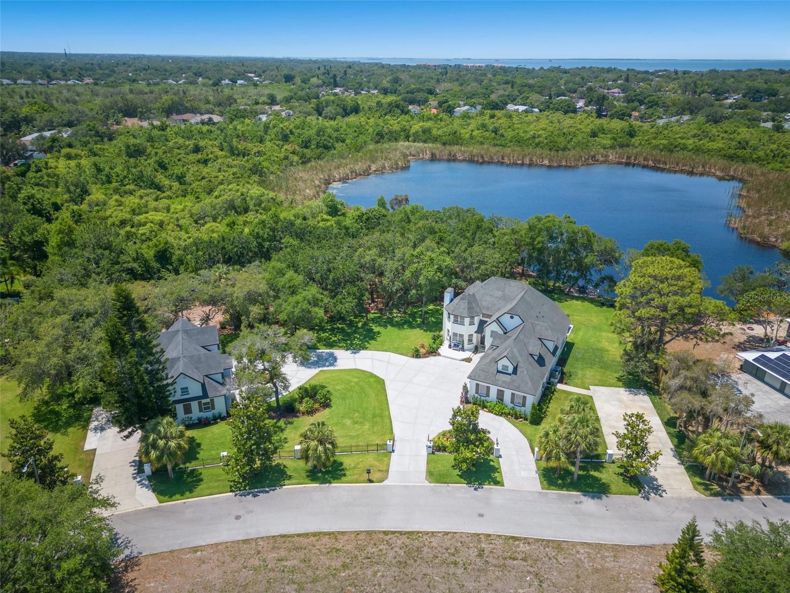 Step into the lap of luxury with this magnificent chateau-style estate property, offering a sublime lakeside living experience. Situated on the tranquil shore of Hidden Lake, this completely remodeled home presents a picturesque waterfront view that will captivate your senses. Designed to cater to the most discerning buyers, this property boasts an array of premium features that will surely impress.
The exterior is meticulously maintained, showcasing a well-kept appearance that adds to its overall charm. The lush yard is meticulously taken care of, thanks to the presence of a 72-head lake-fed sprinkler system.
The interior of the home is a testament to impeccable design and high-end finishes. From the ceramic and luxury vinyl flooring to the coffered ceilings and all-new cabinetry, every detail has been carefully curated. The gourmet kitchen is a chef's dream, equipped with top-of-the-line GE Cafe Series appliances, gas cooking, and elegant marble countertops. The large picture window in the kitchen not only offers breathtaking water views but also fills the space with an abundance of natural light. For wine enthusiasts, the in-home wine cellar adds a touch of sophistication to your culinary endeavors.
Upstairs, the home theater provides a timeless movie atmosphere with surround sound and a built-in bar, creating the perfect space for entertainment and relaxation. The master bedroom is a true sanctuary, featuring a fireplace and a double-entry marble shower with dual rainfall shower heads. The separate contoured tub offers an additional element of pampering. The oversized walk-in closet will impress even the most fashion-forward buyer.
This property boasts an exceptional garage and parking setup that caters to a variety of needs and activities. With a spacious combined 7-car garage and two oversized parking pads, These oversized pads offer enough space to store and park recreational vehicles (RVs), ensuring they are safely and conveniently kept on-site. This is especially valuable for those who enjoy camping or road trips, as you can easily store and prepare your RV for adventures. Furthermore, the parking pads present an exciting opportunity for customization. If you're a fan of pickleball or basketball, one of the pads can be converted into a dedicated court, allowing you to enjoy these popular sports in the comfort of your own property.
The versatile standalone guest house is the epitome of flexibility, catering to various needs and providing multiple benefits. It can serve as an ideal mother-in-law suite, home office headquarters, a comfortable living space for young adult children, or a lucrative short-term rental generating an impressive $60,000 in annual income.
Located just minutes from the historic Tarpon Springs Sponge Docks, where you can enjoy shopping, dining, and seasonal festivities, this luxury lakeside estate offers the ultimate in tranquility and convenience. Don't miss your chance to own this one-of-a-kind property!