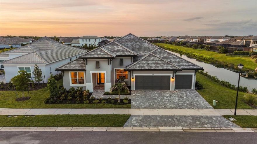 Stunning 2024-built luxury home with waterfront views, situated on a prime cul-de-sac lot, featuring the highly desirable Savannah floor plan with 12-ft ceilings and an open-concept design. This thoughtfully designed home offers 4 bedrooms, 3 full baths, office/den, bonus room, and 3-car garage, with waterfront views from every bedroom.

The gourmet kitchen is a showpiece, highlighted by Cambria countertops and a dual waterfall island featuring storage cabinetry beneath, along with ceiling-height cabinetry, designer backsplash, butler’s pantry, and premium Thermador appliances—including a 6-burner gas cooktop, built-in refrigerator, wine fridge, microwave/convection combo, and TWO dishwashers—ideal for entertaining. The kitchen also includes an under-sink reverse osmosis water filtration system.

Enjoy resort-style outdoor living with a saltwater pool, spa, fire pit, and stunning waterfront views, enhanced by panoramic screen enclosure upgrades.

The spacious primary suite offers lanai access, a stylish accent wall, and brand-new his and hers custom closets. The en-suite bath features a frameless glass shower with dual shower heads and double bench seating, along with upscale finishes.

Secondary bedrooms are set in a private wing with a Jack-and-Jill bathroom, while the expansive bonus room is paired with a secluded fourth bedroom, creating an ideal setup for guests, multigenerational living, or a private retreat.

Additional highlights include wood flooring, custom wainscoting, central vacuum system, a well-equipped laundry room with quartz countertops, cabinetry, and sink, and the home is equipped with built-in speakers throughout, ready for customization and setup, along with a 3-car garage with epoxy floors and EV outlet, along with an outdoor kitchen rough-in ready for your customization.

Located in a low HOA, no CDD community, just minutes from UTC and a short drive to Siesta Key and downtown Sarasota.