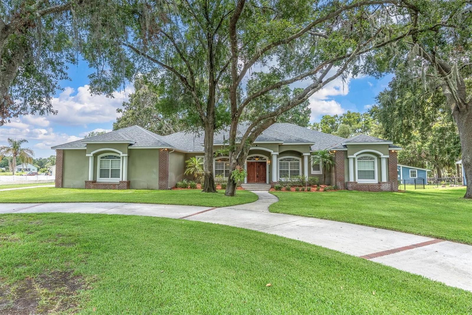 IDYLLIC RANCH HOME ON 2.79 ACRES W/ REWARDING VIEWS OF CONSERVATION & SKI-SIZED LAKE TAYLOR. Impeccably maintained one story ranch style LAKE FRONT home situated on a quiet cul de sac where dreamy Old Florida oak trees welcome you to the property, red brick accents line the circular driveway and a pristine green lawn with full irrigation & fresh landscaping offer unparalleled curb appeal. You will instantly feel the peace and tranquility that surrounds this home. NO FLOOD ZONE. NO HOA. Custom built in 2002 with fine craftmanship and beaming with pride of ownership, this floor plan seamlessly blends functionality & comfort spanning 3367 sqft on one story providing 4 brs, 2.5 baths & 3 car oversized side facing garage with plenty of room for parking. The Florida Style Exterior is enriched w/ red brick accents, white columns, arched windows, NEW ROOF NOV 2024 w/ 30yr 3 dim shingle & charming entrance that beckons you home. Noteworthy investments include a useful Garage Shed 20 x 30 with electricity, 10 yr old Trane AC serviced every 6 mths, Termite Protection, Water Softener & Iron Filter 2 yrs old, New Composite Deck 2023 & freshly painted interior. Double front doors greet guests. Timeless Maple Hardwood Floors flow seamlessly throughout the home with tile in the wet areas. As you enter, a formal dining rm w/ chandelier is to the left and formal living room is to the right. Natural light bathes the family room, highlighted by French Doors which frame the exquisite view. The Spacious family room is anchored by the cozy brick wood burning fireplace w/ mantle and illuminated by 12 foot ceilings, ceiling fan & can lights. Your beautiful spacious kitchen will impress w/ it’s sophistication & function. Cherry Wood Raised Panel Cabinets & Drawers are complimented by Brushed Nickle hardware and surrounded by spacious Granite Counters. Newer appliances include microwave, dishwasher. Garbage disposal range. Expansive breakfast bar with wainscotting seats 5. A cheerful café dining space overlooks the splendid view. Secluded & Spacious Primary Retreat overlooks the beautiful views. The Primary ensuite offers His & Hers Dual sinks, Walk in Shower and his & hers walk in closet. This coveted split floor plan provides three additional well-sized bedrooms and a full bath privately situated. A convenient half bath for guests. A well-sized laundry room provides extra cabinets and storage. Imagine relaxing on your idyllic screened porch framing the canvas of the trees, lake & wildlife like birds & bunnies. A large backyard offers shady spaces to relax or play year-round and plenty of room for a pool. Meander down the wood boardwalk to the newer Composite Deck perfect for making a splash or fishing. Spring fed Lake Taylor, spanning 44 acres, invites you to waterski, wake board or boat your weekends away. Zoned for top schools including Steinbrenner HS. Close to Shopping, Restaurants, Tampa Airport. Create memories & dreams in this beautiful, Private Lake Home!