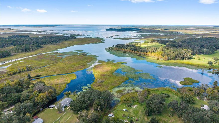 The property is on a canal leading directly to Orange Lake—perfect for boating, fishing, and enjoying true North Central Florida waterfront living near both Orange Lake and Lochloosa Lake.
If you’ve been searching for a place where you can keep your boat at home and head out on the water anytime, this is it. This property features two private boathouses with electric, a deck along the canal, and easy access out to the lake—ideal for early morning fishing or sunset rides.
Sitting on three combined lots totaling just under an acre, you get space, flexibility, and privacy that’s hard to find in lake-area properties. The home is positioned on two of the lots, surrounded by mature oak trees and a beautifully maintained yard that creates a peaceful, natural setting.
Inside, you’ll find a well-kept 3-bedroom, 2-bath mobile home with a spacious primary bathroom. Major systems have been updated, including a newer AC and a recently replaced well and water pump, giving you confidence in the home’s condition.
There’s also an extended carport for covered parking or outdoor gatherings, plus a workshop and shed for storing tools, fishing gear, and lake equipment. The fenced yard adds functionality whether you have pets, equipment, or just want defined space.
If your goal is simple—live near the water, boat with ease, and enjoy the lifestyle around Orange Lake and Lochloosa Lake—this property delivers exactly that.