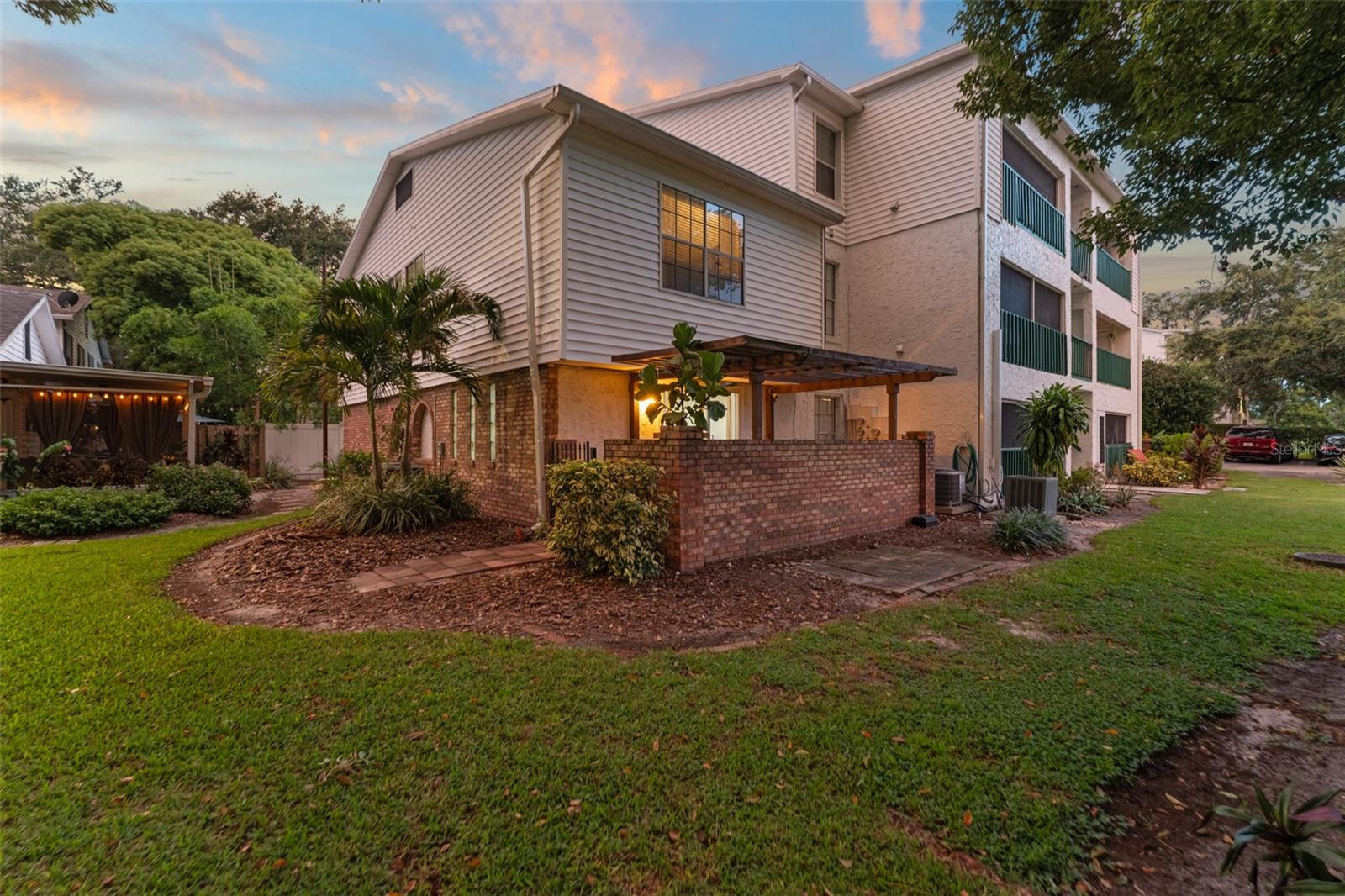 **This house comes with a REDUCED RATE through the seller's preferred lender. This is a lender-paid rate buydown that reduces the buyer's interest rate and monthly payment.** Welcome to a beautifully updated 2-bedroom, 2.5-bathroom corner condominium in the heart of Orlando’s highly sought-after College Park neighborhood. Tucked away in a private, quiet corner of the community, this nearly 1,500 sq ft home offers modern style, thoughtful design, and a layout that invites both relaxation and connection. As you step through the discreet front entrance, you're immediately greeted by an open and airy layout featuring luxury vinyl plank flooring that flows seamlessly throughout the home. To your right, a convenient half bathroom is perfectly placed across from the kitchen—ideal for guests. To your left, the stunning modern kitchen catches your eye with its waterfall countertop, black cabinetry, sleek black appliances, and glass-front cabinet doors. Underlit open shelves and a designer range hood add a touch of warmth and sophistication to this thoughtfully curated space. The galley-style kitchen opens into a formal dining area, anchored by a striking modern light fixture and offering an easy flow into the cozy living room, where a sliding glass door frames views of the private patio. Whether hosting guests or enjoying a quiet evening at home, this open-concept space is designed for comfort and connection. Head upstairs via the staircase with a stylish stair runner, where you’ll find two beautifully appointed bedrooms. Just up the stairs, you’ll find the spacious primary bedroom to your right, featuring an extra-wide built-in closet, serene golf course views, and a tranquil, spa-like ensuite. The primary bathroom is a true retreat, offering dual sinks, backlit mirrors, a skylight, and a glass-enclosed shower with floor-to-ceiling tile—a perfect blend of elegance and function. Across the hall, you'll pass the in-unit laundry closet before reaching the bright guest suite, complete with a built-in closet and an ensuite bathroom featuring a walk-in shower and a black-and-white vanity that seamlessly matches the home’s modern aesthetic. Step outside to your private patio, shaded by a pergola and enhanced by a side gate that offers easy access to the grassy common area—great for pets, gardening, or just enjoying the outdoors. Perfectly located near Dubsdread Golf Course, local shops, cafés, and everything that makes College Park so beloved, this charming and stylish home offers not just a place to live—but a place to belong. Come experience the warmth, style, and soul of 496 W Par St. Welcome home.