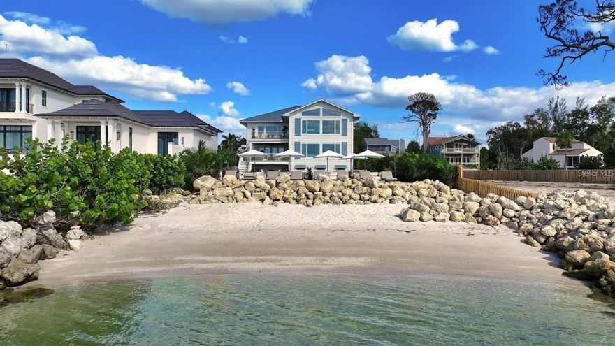 Experience private beachfront coastal luxury at this one-of-one Siesta Key home, thoughtfully curated for comfort, style, and entertainment - by Pham Development. Perfectly positioned off the Gulf, with gorgeous ocean views throughout the rooms - you can watch a world-class sunset view from your master bedroom. Spanning over 6,468 square feet under air and 9,080 total square feet, this exquisite residence captures the essence of resort-style waterfront living on more than half an acre of pristine Gulf-front land. Be at ease with a surrounding elevated riprap shoreline and the imported rocks, offering both protection and privacy.

Pull into the property through the gated entry, with a paved driveway for ample parking. The ground level offers a 3-car garage, spacious private fitness studio with AC, large flex space/storage room, and huge game room that leads out to the truly special backyard - with premium turf, silica sand and a putting area. Host a sunset dinner with the full outdoor kitchen, including a freezer, wet bar, beverage center, ice machine, and 6-burner grill. Have a drink while sitting in the pool facing the ocean, relax in the champagne spa hot tub, or tan on the sun shelf. Put your toes in the sand area of the backyard, or take the paver steps down to the private beach and swim in the ocean - the ultimate paradise.

Wake up to the panoramic views of the Gulf of America and Sarasota Bay, that create a daily masterpiece of color and light, and have a coffee on the master bedroom's private balcony. With 6 bedrooms, 5 full bathrooms, and 2 half baths, you can host more family and guests - along with the second living room/media room. All of the bedrooms have custom built-in closets, and the spacious ocean-view master bathroom leads to two spacious walk-in closets. The home features high-ceilings, beautiful hardwood flooring throughout, and cypress beams. The living and dining room area have a fireplace, and the open-floor plan leads out to another large balcony overlooking the ocean. Enjoy the gourmet custom kitchen with Thermador gas appliances, a walk-in pantry, and an extra large quartz island with seating.

An elevator connects the 3-level home through the grand living spaces that flow seamlessly toward the water, blending indoor sophistication with the beauty of the coast. The lush tropical landscaping evokes the serenity of a private resort. Located just minutes from Siesta Beach, the Village, and the North Siesta Bridge, this rare coastal jewel offers the ultimate combination of elegance, exclusivity, and Gulf-front tranquility—a move-in ready residence truly without equal on Siesta Key.

Please go to our Youtube link and see the video of this gorgeous property:
https://youtu.be/qv5Iljf5d5U?si=dTNKY3LAuFQH6xBc