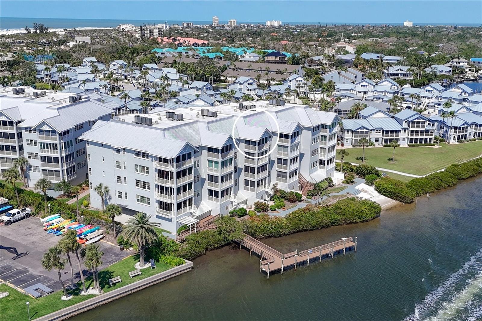 RARE OPPORTUNITY to own this beautifully remodeled, TURNKEY furnished fifth floor, PENTHOUSE, with soaring cathedral ceilings and incredible, UNOBSTRUCTED VIEWS OF THE INTRACOASTAL, one of only five units like it in Dolphin Bay! This stunning condo offers luxury living in one of Siesta Keys most sought-after gated, dog friendly communities. Only the top floor boasts these dramatic ceilings, vaulted in the living and dining areas, primary suite, and lanai. Relax in the lanai with either open air or hurricane sliders, as dolphins swim by and boats glide past. The chef's kitchen is a dream - both stylish and smartly designed. It features high-end appliances, custom solid wood cabinetry with clever built-ins, two wine fridges, a separate bar area, and a spacious island with striking granite counters and backsplash. Plantation shutters adorn the sliders to the front patio from the additional sitting/den area in the kitchen. Wake up to sunrise views from the primary bedroom and back porch, enjoy sunset skies from the front. The primary suite overlooks the water and includes a walk-in closet and ensuite bath with dual vanities, plus dedicated makeup vanity and walk-in shower. The guest bedroom includes a walk in closet and has a slider to its own front patio to enjoy beach breezes. HURRICANE RATED windows and sliders offer peace of mind, and a PRIVATE GARAGE (rare on Siesta Key!) offers secure parking and extra storage. Premium engineered hardwood floors and solid core doors throughout. HVAC Jan 2021. Dolphin Bay is a friendly, social community with fantastic amenities: three tennis courts, a fitness center, heated pool and spa, clubhouse, and day dock. It's easy to connect and make new friends with all the social activities available. Located across the street from the world-famous Siesta Key Beach. Hop on the free open air Siesta Key trolley that stops outside the gates to enjoy boutique shopping and dining options from the village all the way down to Turtle beach!