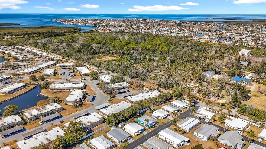 Welcome to A Place in the Sun, a quaint 55+ cooperative community in New Port Richey! This small enclave of homes features NO LOT RENT (you own a share of the park), and a nice clubhouse, which features a community pool as well! This home was COMPLETELY RENOVATED with full permits pulled after the hurricanes in 2024. This home has plenty of outdoor living space, with a carport, storage room, screened in lanai, back patio with pergola, and additional storage shed! The floor plan of this home is split. with the living space on one half of the home, and the sleeping quarters on the other side. The living space is completely open, with the living room, dining room, and kitchen flowing together. There is new lighting throughout, with beautiful granite countertops, new cabinetry, and stainless steel appliances in the kitchen. The bedrooms are split, with the guest bedroom in the front of the home, and the master suite in the back. Washer and dryer are available in the home, and both bathrooms features walk-in showers. The home is being sold furnished as seen in the photos. This beautiful home is ready for its new owner; schedule your showing today!