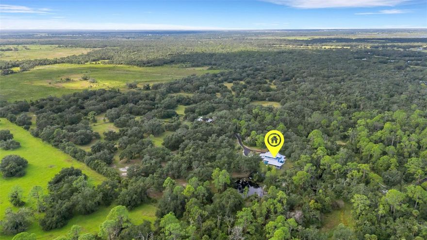 Experience peaceful country living on this rare 90-acre ranch in the heart of Myakka City. As you enter, a newly paved, winding canopy driveway welcomes you through mature oaks and pastureland, setting the tone for the private retreat that awaits. The west property line spans approximately 2,500 feet along protected state park land, ensuring long-term privacy with no future neighboring development and uninterrupted natural views. Designed for those who value space, seclusion, and a true rural lifestyle, the land offers existing ATV trails, open pasture, shaded paddocks, and multiple areas ideal for expansion or additional amenities.

The property includes a well-kept 4-stall horse barn with a metal roof, feed/tack space, and turnout paddocks already in place — perfect for equestrian use, hobby farming, or livestock. Whether you're riding, exploring, hunting, or simply taking in the quiet, this acreage delivers the atmosphere of a private nature preserve with the usability of a working ranch.

The residence sits tucked within the trees and blends into its surroundings with a welcoming front porch finished in Trex decking. Inside, vaulted ceilings with tongue-and-groove planking and beams, hardwood flooring, and a cozy wood-burning fireplace bring warmth and rustic charm. A large breakfast nook framed by picture windows overlooks the property, while a bright Florida room and second-story loft provide additional flexible living space. A rear Trex-decked lanai offers another quiet spot to take in sunrise or evening breezes.

With unmatched privacy, protected natural borders, mature landscape, and room to roam, this ranch setting offers a truly special opportunity for those seeking acreage, lifestyle, and land preservation in one of the area’s most peaceful corridors.