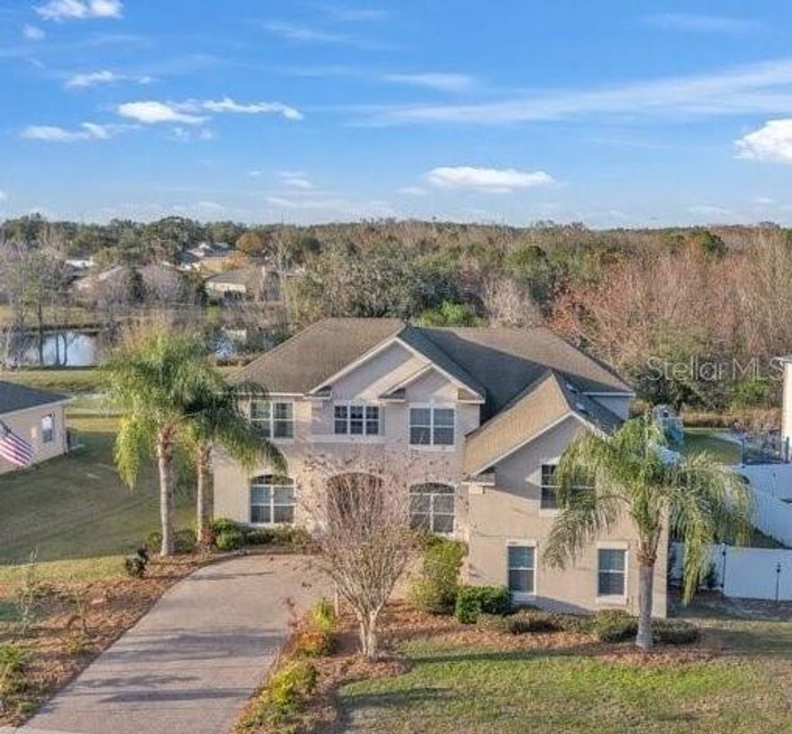 Located within the gated community of Spring Ridge Estates, this pool home offers a layout designed for everyday living, with indoor spaces thoughtfully centered around the outdoor living area. Set on a quiet cul-de-sac lot with conservation and water views, the home provides a sense of privacy while remaining conveniently located just minutes from downtown Eustis and Mount Dora, as well as shopping, dining, and major commuter routes.

As you enter through the double front doors, you are welcomed by a foyer with soaring 20-foot ceilings and a striking chandelier, immediately drawing your eye straight through the home to the outdoor living space beyond. The open floor plan flows naturally from the main living areas outward, reinforcing the home’s indoor-outdoor design and sense of openness.

The first-floor primary suite offers private, direct access to the covered outdoor area, along with a spacious en-suite bath and walk-in closet. The kitchen overlooks the main living area and features an island, breakfast bar, dining space, and generous cabinetry.

Upstairs, the home features four additional bedrooms, a second living room, and a large bonus/game room that can easily function as a media room, home office, or fifth bedroom. From the upper level, there are water and conservation views, adding to the home’s sense of space and privacy.

The outdoor living area includes a screened pool with waterfall feature, a covered lanai, and an outdoor kitchen with a full pool bath, offering direct access from the pool and living area—ideal for year-round Florida enjoyment.

With over 4,000 square feet, multiple living spaces, and a thoughtful layout, this home offers exceptional flexibility for a variety of lifestyles. Located within one of Eustis’ most desirable gated communities and close to Highways 441, 44, and 429, this property combines space, privacy, and convenience in a setting that is increasingly hard to find.