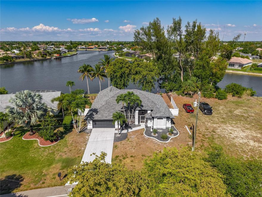 Completely renovated and move in ready, this beautifully updated waterfront home offers the perfect blend of modern finishes, functionality, and Florida outdoor living. Featuring 3 BEDROOMS, 2 BATHROOMS, PLUS A DEN/OFFICE, this home was thoughtfully designed with both comfort and entertaining in mind. Best of all, NO HOA, NO WATER ASSESSMENTS and NO FLOOD INSURANCE REQUIRED.

Step inside to soaring VAULTED CEILINGS, LED LIGHTING throughout, and a split floor plan with an open concept layout centered around an expansive QUARTZ WATERFALL ISLAND that immediately becomes the heart of the home. The stunning kitchen features 42 INCH CABINETS, ample storage, stainless steel appliances, sleek finishes, and plenty of space for hosting family and friends.

The spacious primary suite offers a relaxing retreat with TWO WALK IN CLOSETS, a SOAKING TUB, and a beautifully updated ensuite bathroom featuring luxury DUAL SHOWER HEADS with a rainfall, designed for a spa like experience.

The guest bathroom has also been tastefully updated and also features a stunning RAINFALL SHOWER along with modern finishes that continue the home's cohesive renovation style.

Outside is where this property truly shines. Situated on a TIP LOT at one of the widest sections of the canal, this property offers expansive water views and an incredible backyard setting that feels open and private at the same time. Enjoy your FULLY FENCED YARD complete with a CONCRETE SEAWALL, PRIVATE DOCK with electric already running to it, and a dockside CABANA with a fully functioning HOT TUB. Spend your evenings fishing right from your backyard where you can catch large mouth bass, bluegill and more!  Launch your kayak or paddle board directly from your property, or simply relax and enjoy the peaceful waterfront atmosphere.

Additional updates include a NEW ROOF IN 2022 and extensive renovations throughout the home that give it a fresh, modern feel while still feeling warm and inviting.

Conveniently located just 5 MINUTES FROM SHOPPING, DINING, NIGHTLIFE and everyday conveniences in Cape Coral, this home offers easy access to everything while still providing the peaceful waterfront lifestyle you have been looking for.