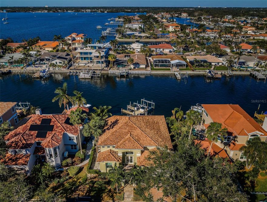 MOVE-IN READY! GORGEOUS CONTEMPORARY WATERFRONT ELEGANCE OFFERS BEAUTIFUL VIEWS AND AN UNFORGETTABLE LIVING EXPERIENCE! Impressive covered entry transitions to a soaring foyer and towering 19ft-high great room overlooking the waterfront. Elegant driftwood-style porcelain flooring and lovely modern lighting/fixtures give the home a distinctive luxury appeal. Great room features a built-in media center with soaring tumbled marble-façade, an array of tall windows overlooking the pool deck and waterfront, and a wonderful wine/beverage wetbar with glass-enclosed wine wall. Resplendent gourmet kitchen boasts exquisite quartz surfaces, shaker-style coastal cabinetry, high-end Thermador appliances, gas cooking, built-in refrigeration, and an island prep center with large breakfast bar, sizable hidden pantry, and lovely tile backsplash. The exceptional indoor laundry provides quartz counters and cabinetry to match the kitchen, a built-in sink and generous storage. The owner’s suite is pure bliss: with a bedroom that opens to and overlooks the pool/waterfront, features an elaborate built-in cabinetry storage system with media center, and contains an outstanding walk-in closet system & substantial 2nd closet system. The owner’s bath is a posh, pampering sanctuary with elegant dual vanities, a richly-encased jetted spa Jacuzzi tub for two, and a magnificent zero-entry multi-head rainshower. Upstairs you’ll find 3 spacious, well-appointed bedrooms. All baths are beautifully finished with fine materials and custom features. The many luxury amenities of this remarkable home include whole-house lighting, electronic window treatments in bedrooms and extensive multi-media capabilities. Out back discover a dazzling waterfront paradise with gorgeous 250sqft covered deck with pool bath and large quartz bar overlooking the water. Superb outdoor kitchen enjoys fine quartz/tumbled marble finishes, Alfresco natural gas cooking center, and Subzero icemaker & refrigeration. Elegant travertine paver deck extends to a terrific built-in firepit and fabulous free-form heated & cooled pool/spa (with a private hot/cold water shower). The brilliant boat dock setup includes a 25,000lb boat lift with shore power/water, jetski lift, 2 kayak/paddleboard lifts, dock lighting, fish cleaning station and seating bench. Plush common areas share a lavishly-detailed clubhouse, billiards room, large fitness center w/his & her facilities, library, 3 pools, tennis courts & private beach – all at a surprisingly affordable monthly fee. Just 5 min to beaches, 10 min to downtown St. Pete and 25 min to Tampa Airport.