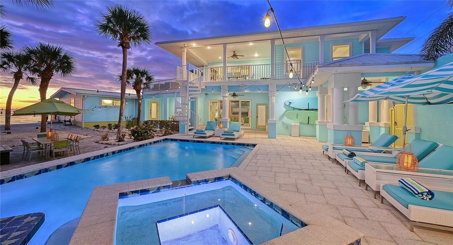 Escape to paradise where pristine sands meet the azure waters of the Gulf of Mexico. Nestled amidst lush tropical foliage, this remarkable four-bedroom Key West-style beach home comes with the bonus of deeded bay access! Spanning more than 3,200 square feet and having undergone an extensive renovation with upscale enhancements that began in 2014 and completed in 2023, this home's most notable upgrades include impact windows/sliders throughout, newer roof, whole-house generator (currently being installed), and brand-new seawall (2023). The elaborate and impressive courtyard entrance awaits beyond the remote-access entry gate, welcoming you to a luxurious beach lifestyle.  As you step inside the central residence, prepare to be mesmerized by breathtaking panoramic beach and sunset views glimpsed through magnificent walls of windows in the expansive great room, highlighted by its vaulted ceiling, electric fireplace, and pecky cypress accents. This unique residence boasts a thoughtfully designed layout equipped with a state-of-the-art smart home automation system and refinished terrazzo floors that connect each room. The hub of the main home is centered around the masterful gourmet kitchen, featuring top-of-the-line Viking Pro appliances, dual dishwashers, wet bar with two refrigerator drawers, and double built-in ovens with warming drawers. An expansive island/breakfast bar takes center stage, adorned with custom countertops embedded with exquisite oyster shells, while an abundance of custom white shaker cabinetry provides ample storage. A butler's pantry and generous walk-in pantry/storage are the perfect finishing touches to this culinary haven. The primary suite is a sanctuary, featuring a walk-in closet, modern bathroom, and private access to an outdoor deck overlooking the beach. The first guest suite (currently being used as a den) completes this main living area. The beautifully appointed two-bedroom, two-bath guest/in-law cottage is a retreat for family and friends. With a private entrance, its own laundry room, and porcelain tile throughout. Tray ceilings add an elegant touch, while a media room (also accessible from the main house), living room, dining area, and full kitchen with an island provide all the amenities overnight guests could desire. The luxuries of this property extend outdoors. Newer impact glass sliders from the guest house open to the elaborate pool area, while the main house offers direct access to the Gulf from multiple rooms. Step outside to discover a custom-built pavilion that elevates outdoor living to new heights. A wonderful cabana houses the fully equipped summer kitchen with seating for eight, stainless-steel grill, dishwasher, and disposal. Dive into the resort-style PebbleTec saltwater swimming pool, complete with a heater/chiller for year-round enjoyment. Discover built-in benches, a swim-up bar with seating, inviting spa, and upgraded Shellrock deck pavers that lead directly out to the beach. Enjoy an indoor/outdoor audio system with Sonos speakers, electronic blinds, upgraded internet with enhanced exterior access points, and outdoor infrared surveillance cameras for added security. Access to the pool bath off the media room adds the right amount of convenience. Every detail has been carefully considered to create a truly extraordinary beach experience.