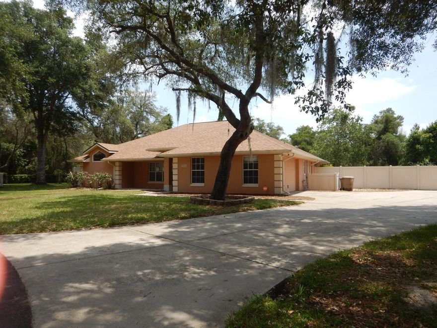One or more photo(s) has been virtually staged. This ranch-style home sits on a secluded 0.49-acre lot in Leesburg, offering three bedrooms, two bathrooms, and a split bedroom floorplan designed for privacy and flexibility. Mature oak trees, creating natural character and established shade. Inside, stainless steel appliances anchor the kitchen, which flows smoothly through sliding glass doors and French doors to outdoor living spaces. The thoughtful interior layout maximizes both communal areas and private retreats, with the split bedroom design ensuring separation between the primary suite and secondary bedrooms. A screened lanai provides a comfortable retreat for morning coffee or evening relaxation, while a screen-enclosed pool with poolside entertaining patio invites year-round gatherings and recreation. The fenced backyard creates a secure outdoor sanctuary where household members and pets can play safely. A covered front porch welcomes you home with classic charm, while a side entry garage and extra-large driveway with additional parking offering practical convenience for multiple vehicles and storage needs. The new roof installed in May 2026 features architectural shingles, protecting your investment with modern durability and enhanced curb appeal. A remote-controlled thermostat adds contemporary efficiency to daily living, allowing you to adjust comfort settings from anywhere in the home or remotely. Proximity to Lake Square Mall shopping means dining, retail, and services are minutes away, making errands and entertainment easily accessible. Whether you need groceries, clothing, or residents dining options, everything is within a short drive. This property combines functional layout, established outdoor features, and genuine bones ready for your vision and personal touches.