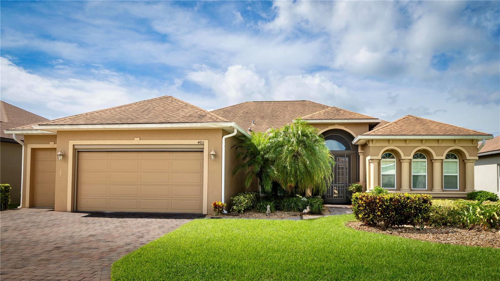 Welcome to the next chapter of your life in beautiful Lake Ashton—Central Florida’s premier 55+ active-adult community. This immaculate 2,512 sq. ft. residence perfectly blends tasteful style, timeless elegance, and the easygoing charm of Florida living, and the CDD debt is PAID IN FULL. With 3 generous bedrooms, 2 full baths, and a versatile den/office, the open-concept design—highlighted by soaring 10-foot ceilings and stately 8-foot doors—feels both grand and inviting, ideal for relaxed everyday living and gracious entertaining. From the moment you arrive, you’ll be captivated by the vibrant landscaping, colorful plantings, and welcoming front screened entry. Inside, the spacious kitchen shines with rich cabinetry featuring striking bump-outs, bump-ups, and exquisite moldings. Stainless steel appliances, including a cooktop and built-in ovens, are bathed in the natural glow of a large solar tube, while a roomy pantry keeps everything within easy reach. Even the laundry room enjoys granite counter surfaces for a refined touch. The living room’s elegant, coffered ceiling adds architectural drama, while the expansive primary suite offers a peaceful retreat with abundant natural light, two impressive walk-in closets, and a spa-like master bath adorned with graceful arched windows. Custom tile flooring flows seamlessly through the living, dining, kitchen, dinette, and baths, creating a cohesive and polished look. Step out to the splendid veranda—perfect for morning coffee, afternoon gatherings, or quiet evenings. The space features a ceramic tile floor and has been expanded with a hard roof extension, making it a year-round pleasure. The deep 110-foot lot offers endless possibilities for lush landscaping or garden accents, and thoughtful details like custom fans, hardware, and lighting add comfort and style throughout. At Lake Ashton, you’re not just buying a home—you’re embracing a vibrant lifestyle. Here, days can be filled with two 18-hole championship golf courses, a 26,000 sq. ft. clubhouse, state-of-the-art Health & Fitness Center, indoor and outdoor swimming pools, pickleball courts, a bowling alley, theater, on-site restaurant, and an ever-changing calendar of social events and clubs. This is more than an opportunity—it’s the Florida dream brought to life. Schedule your private showing today and see for yourself why this home truly has it all.