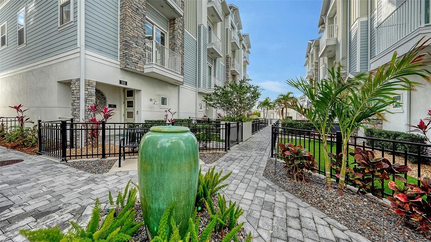 Discover an incredible opportunity to own a stunning townhouse in the heart of Sarasota’s historic Laurel Park District. Step through the gated, low-maintenance front yard overlooking the community fountain, and you will enter a foyer that leads to the luxury of a private elevator providing effortless access to every level of the home. Designed for both comfort and entertaining, the expansive living area features an open-concept kitchen that seamlessly flows into the dining and living spaces. The kitchen is a chef’s dream, with stainless appliances, solid stone countertops, and a stunning designer tile backsplash. Adjacent to the main living area you will find a half bath for you and your guest’s convenience. The 3rdlevel of the home is dedicated to the owner’s primary suite offering a spa-like bathroom featuring a large walk-in shower, a beautiful double sink vanity with extraordinary counter space and cabinets, elegant tile work, and a custom walk-in closet. Just steps from the primary suite, there is a well-appointed laundry area complete with a washer, dryer, and a large wash sink for added convenience. Adjacent to the primary suite, you will find a space perfect for a small office, TV area, playroom, or even a small library. The top level offers two additional en-suite bedrooms, providing ample space for guests or family. Beautiful engineered hardwood floors run throughout, complemented by beautiful tile in all the bathrooms along with a neutral color palette that suits any style. As an end unit, this home is filled with natural light, thanks to additional windows adorned with custom wood and fabric blinds. Every level features two balconies, creating a seamless blend of indoor and outdoor living.  This exceptional downtown residence also includes a private two-car garage, and a large storage closet. Embrace the best of downtown living in this low-maintenance home, ideally situated within walking distance of Sarasota’s vibrant Main Street, the Bayfront, top-rated restaurants, art galleries, unique boutiques, close proximity to the airport, and three grocery stores. Enjoy the benefit of the Legacy Trail with miles of scenic views, several parks—including Laurel Park and Payne Park, which offers opportunities for amazing dog walks and a dog park—several tennis courts, a well-equipped play area for children, and much more. This home, with low HOA fees, also offers the benefit of being located close to Sarasota’s renowned beaches, including Siesta Key and Lido Beach. You do not want to miss this amazing opportunity to experience city living at its finest—right at your doorstep.