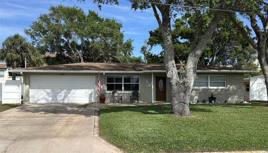Welcome to this bright and inviting Dunedin gem and Florida charm.  This 3-bedroom, 2-bath home is in the heart of Dunedin! Renovated top to bottom, freshly painted inside and out, this home offers a clean, updated look and move-in-ready appeal. Perfect for both everyday living and entertaining, the layout offers a seamless flow between living, dining, and kitchen areas. The spacious living room has custom plantation shutters and features a built-in bar area—perfect for entertaining guests or relaxing at home. The Large kitchen features beautiful quartz countertops and solid white wood cabinetry, offering both durability and timeless style, with ample workspace and storage. In addition newer appliances were installed in December 2024. Comfortable bedrooms and functional design make this home an excellent choice for those seeking both style and practicality. The spacious primary suite is a true retreat, featuring soaring cathedral ceilings, a private sitting area, and walk-in closet.  A well-appointed en-suite bath with a luxurious walk-in shower featuring dual showerheads, offering a spa-like experience, dual sinks and a separate toilet room. Enjoy Florida living with a paved front walkway and cozy sitting area on the front porch to watch sunsets or visit with neighbors. French doors lead to an enjoyable paver patio in the backyard—ideal for entertaining for barbecuing. The backyard also includes a workshop, providing great space for hobbies or additional storage, and still offers plenty of room to add a pool. The hall bathroom is thoughtfully designed with an exterior door for convenient access, making it perfect for future pool use.  The Indoor laundry room offers added comfort and functionality, keeping chores out of the heat and weather with ample space for storage and organization. The laundry room also provides a practical, dedicated area to handle everyday tasks with ease. The home features a spacious 2-car garage with extra laundry hookups and a newly finished epoxy floor, perfect for durability and a clean, modern look. A/C units were replaced in December of 2024. An added bonus: flood insurance is covered through November of 2027 with a FEMA-supplied policy, offering peace of mind and significant savings. Roof was installed in May of 2014. Whether you're entertaining guests or enjoying a quiet evening outdoors, this home delivers. Situated close to everything that makes Dunedin special—vibrant downtown, waterfront parks, Honeymoon Island and top local attractions—this is a lifestyle opportunity you won’t want to miss.