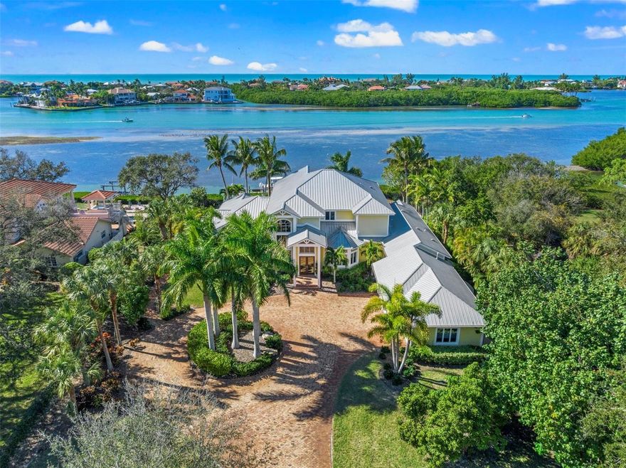 Presenting an unparalleled opportunity for architectural elegance and opulent living in this exquisite 1.2-acre bayfront estate that is a testament to coastal luxury. With 143 feet of panoramic water frontage overlooking Casey Key, this residence is strategically positioned to capture breathtaking views of the entire bay and the Intracoastal Waterway, along with breathtaking sunsets. As you pass through the front glass double doors, the inviting entryway unveils soaring 22-foot ceilings and a grand staircase that curves gracefully upwards. Meticulously designed living spaces showcase detailed craftsmanship and magnificent architectural elements, setting the stage for a lifestyle defined by sophistication and comfort. Principal rooms are generously proportioned and feature 12-foot ceilings and large windows that flood the interior with natural light. A stunning fireplace and custom built-ins anchor the living room, while the open-concept living space seamlessly flows to the dining area and chef-inspired kitchen. Ideal for entertaining, the kitchen boasts white shaker cabinetry, granite countertops, stainless steel appliances, a Sub-Zero refrigerator, and a 6-burner gas stove with dual ovens by Fisher & Paykel. Enjoy bay views from nearly every room, celebrating the perfect harmony between architecture and landscape. Outside, you’ll discover a lush private paradise at the heart of which is a beautiful custom saltwater pool with a sun shelf, bench seating, water flow features, LED lighting, and a hot tub nestled in a charming cedar arbor. A screened-in patio with a summer kitchen adorned with cypress ceilings offers an ideal setting for alfresco dining while enjoying tranquil views of the shimmering blue waters of the bay. The tropically landscaped yard gently slopes to the water's edge, where you can witness dolphins and manatees swimming. The bayfront dock with a 10,000-pound boat lift and rotating jet ski lift provides convenient boat access to the Gulf of Mexico. As you explore the expansive outdoor space, you'll discover a host of thoughtfully designed features, ensuring both functionality and luxury, including a kayak launch, Trex dock and decking, aluminum fencing, brick paver walkways, outdoor shower, fruit trees, well-fed irrigation system, impact-resistant glass, Hardie board cement siding, Standing Seam Galvalume roof, and prewiring for a generator. Embrace a lifestyle of grandeur and comfort in this one-of-a-kind bayfront estate, offering the epitome of luxury indoor/outdoor living. Schedule your private tour of this waterfront masterpiece today.