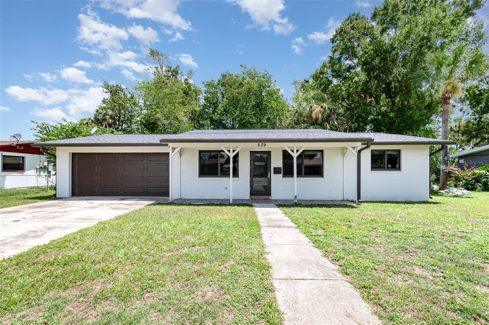 Fully Renovated Modern Gem Near the Beach. Step into refined elegance with this beautifully renovated residence that redefines contemporary living. Every detail of this three-bedroom, 1.5-bath home has been thoughtfully updated to deliver both style and functionality. A host of upgrades includes a new roof (2021), new A/C system, impact-rated windows with built-in shades, new garage door, water heater, and sleek porcelain tile flooring throughout, including in both bathrooms. The heart of the home—the kitchen—shines with quartz countertops, stainless steel appliances, and a modern design that effortlessly connects to the open living and dining areas, perfect for entertaining or relaxing in style.
The spacious two-car garage adds convenience, while the absence of an HOA gives you the freedom to truly make it your own. Located just minutes from the World’s Most Famous Beach, Daytona International Speedway, Tanger Outlets, and a variety of dining and shopping options, this move-in-ready home offers the perfect blend of luxury and location. Schedule your private tour today—this stunning property won’t last long!