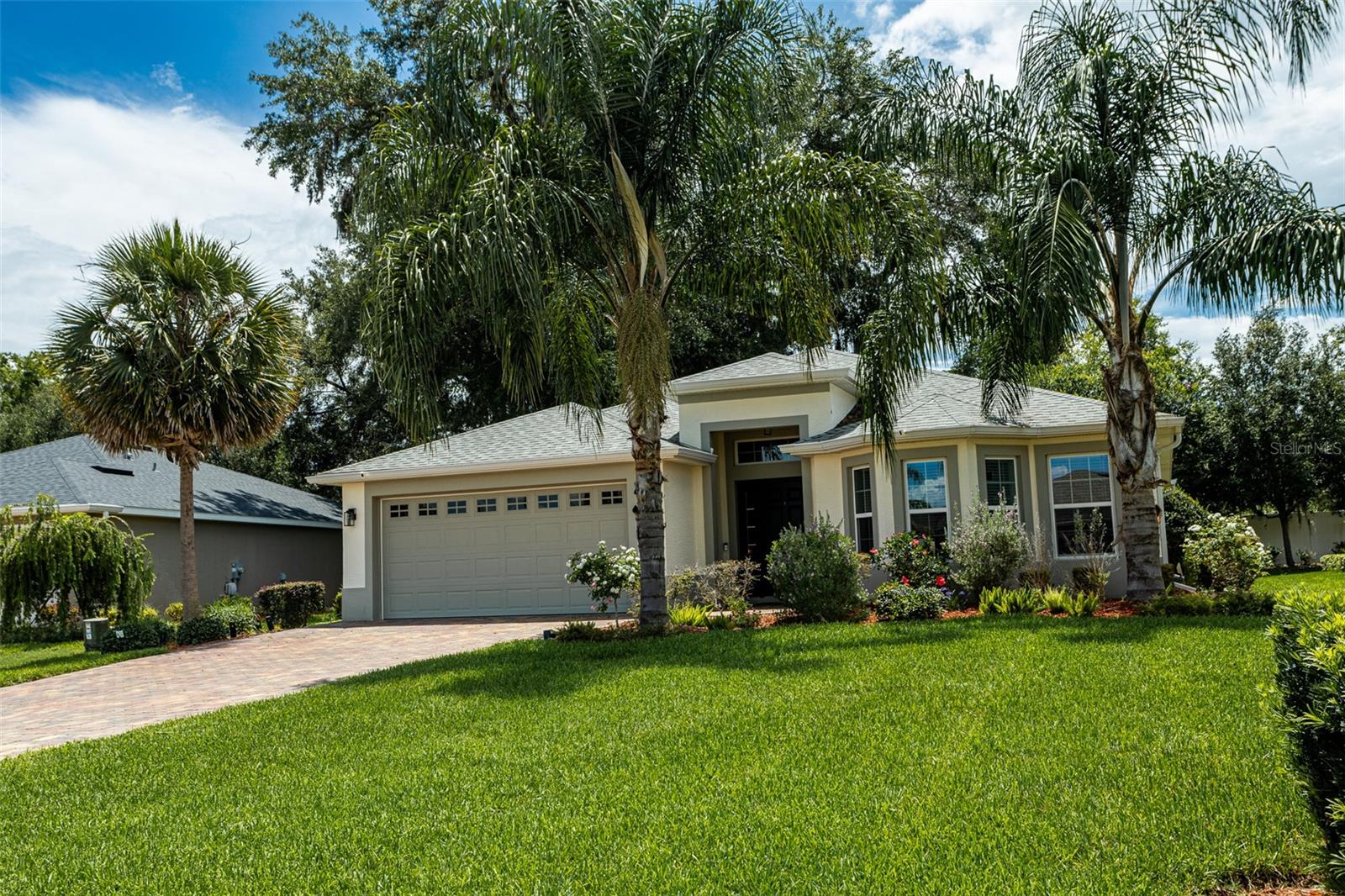 Your dream home awaits! Built in 2020, this beautifully maintained Osprey model is located in the highly sought-after gated community of Lakeside Landings (Enclave). Featuring 3 spacious bedrooms, 2 full bathrooms, and a 2-car garage with an extended brick paver driveway, this home offers both comfort and curb appeal. Step into a welcoming foyer that opens up to a bright and airy open-concept living and dining area, perfect for entertaining guests or enjoying quiet evenings at home. The chef’s kitchen is a true centerpiece, boasting granite countertops, a large breakfast bar, stainless steel appliances, and ample cabinet space. The primary suite is a peaceful retreat with a charming bay window, walk-in closet, and a luxurious en-suite bathroom complete with dual vanities and a walk-in shower. Step outside to your private screened-in lanai, ideal for morning coffee or relaxing evenings, with a serene view of the backyard. Residents of Lakeside Landings enjoy resort-style amenities, including a sparkling pool with waterfall, tennis courts, boat dock with access to Lake Miona, a dog park, playground, and more! With lawn maintenance included in the HOA, you’ll have more time to explore The Villages’ shopping, dining, and free nightly entertainment, all just minutes away with easy access to major highways. Don’t miss your opportunity to own this gem — schedule your private showing today!
