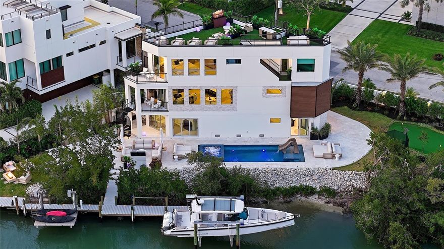 Welcome to 1406 Tangier Way, a breathtaking expression of coastal contemporary luxury in San Remo Estates in Sarasota, where architectural excellence meets waterfront serenity. This 3,069 sq. ft., two-level masterpiece is a seamless blend of sophistication, innovation, and artisanal craftsmanship, offering four bedrooms, three full baths, and unparalleled views of Sarasota Bay.

Every detail has been meticulously curated, from the custom Doca cabinetry, hand-crafted and imported from Spain, to the high-grade Portuguese porcelain countertops that extend from the kitchen to the ceiling, creating a striking visual statement. The gourmet kitchen is equipped with state-of-the-art Fulgor Milano appliances, an oversized island, and bespoke finishes, setting the stage for an elevated culinary experience. Walls of strategically placed windows flood the interiors with natural light, enhancing the contemporary loft-inspired aesthetic while showcasing the property’s unrivaled water views. The second-floor master suite is a sanctuary of refined elegance, featuring a private office, floor-to-ceiling water views, and a spa-inspired en-suite bath adorned with intricate, high-end tilework, exuding a sense of tranquility and indulgence.

Ascend to the rooftop terrace, where artificial turf, a wet bar, and panoramic views create an unforgettable setting for sunset soirees and intimate gatherings under the stars. The outdoor living space is nothing short of an oasis, boasting leather-marble walkways, a champagne spa, a gas fireplace, and a fully equipped outdoor kitchen, designed for seamless alfresco entertaining. An automated mosquito misting system ensures year-round comfort, while Control4 smart home technology integrates lighting, climate, security, and entertainment at the touch of a button, delivering an effortlessly luxurious lifestyle. Boaters will revel in the two newly constructed boat lifts and direct access to Sarasota Bay, making this home an extraordinary retreat for waterfront living at its finest. 

Built with strength, timeless beauty, and the highest level of craftsmanship, this extraordinary waterfront residence is truly a rare find—a once-in-a-lifetime opportunity to own an unparalleled slice of Sarasota’s coastal paradise. Schedule your private showing today—this exclusive sanctuary could be yours.