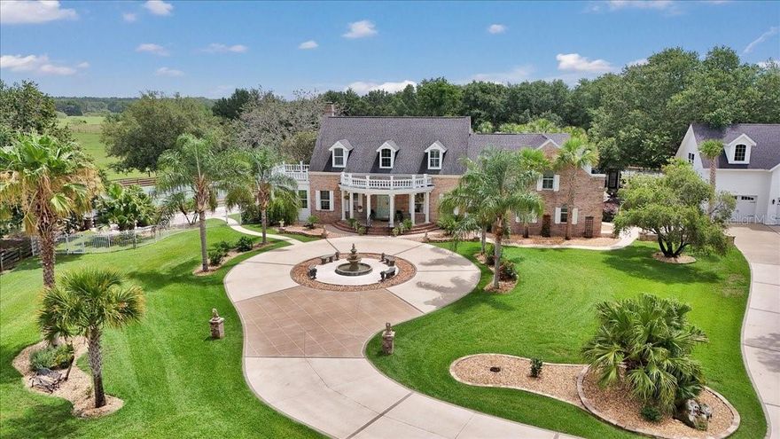 Welcome to paradise in Oxford! This is a rare opportunity to own a one-of-a-kind luxury compound—private, peaceful and ideally within two miles of The Villages. Just five miles from Lake Sumter Landing Market Square, you’ll enjoy easy access to shopping, dining, nightlife, movies and live music. On a beautifully landscaped six-acre corner lot with two gated entrances, this meticulously designed estate offers nearly 9,000 square feet of total living space across multiple structures. The property is the ultimate entertainer’s dream and a private oasis like no other. The main residence features five bedrooms, three full baths and two half baths. The primary suite is on the main floor, along with a formal living room, formal dining room, a cozy family room with gas fireplace, a workout room and all-season sunroom with dual south-facing French doors. The heart of the home is the eat-in kitchen with a Cambria quartz island, ideal for gatherings and everyday living. Upstairs, a bonus family room connects to four bedrooms, one with a private en suite and two sharing a Jack-and-Jill bath. Go outside to your private resort-style retreat featuring an expansive covered lanai, two cabanas, two pickleball courts, an outdoor kitchen, game room, tavern, guest cabin, she shed, man cave, bocce ball and shuffleboard courts. The centerpiece is a concrete/gunite saltwater pool with tile accents, six waterfalls and deck jets—surrounded by lush landscaping, fountains, a peaceful pond, and an oversized pool house with a changing room and fireplace. Car enthusiasts will love the oversized four-car garage with epoxy floors, and upstairs, enjoy a full movie theater and spacious craft room for creative pursuits or additional living quarters. A second detached four-car garage offers even more space for vehicles, ATVs, boats or toys. Several outdoor structures offer flexibility for ADU conversion, making this estate ideal for multi-generational living, potential rental income or luxury guest accommodations. There’s even a beautiful pasture out front so bring a few animals and enjoy the tranquility of country living. Schedule your private showing today and experience this one-of-a-kind compound for yourself.