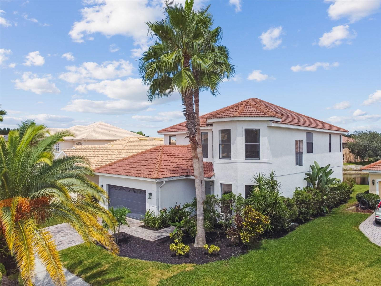 Upgrades abound in this contemporary styled waterfront home located on a quiet cul-de-sac in the prestigious gated community of Cory Lake Isles! Upon entering the home through the custom imported front door, you are immediately struck by the soaring two story ceilings in the front formal living area with bay windows! The entire first floor boasts high end travertine flooring! As you approach the center of the home, you enter a spacious family room with spectacular views of the water through 8 foot tall sliding glass doors that lead to a cozy covered lanai with paver flooring and a stunning travertine covered privacy wall and decorative electric fireplace! The fabulous gournet eat-in kitchen also has a sliding glass door that leads to the lanai along with staggered 42" cabinets with crown molding, top of the line stainless appliances, granite countertops and backsplash, a huge walk-in pantry and custom butler's pantry with a wine refrigerator that leads to the formal dining area! There is a beautifully decorated half bath conveniently located in the center of the home! You reach the second floor via a stairway secured by contemporary cable railings! All of the upstairs floors are engineered hardwood except for one guest room and wet areas. One of the 3 guest rooms has its own en suite bath, and there is a handy study area in the hallway! Double doors lead to the spacious primary bedroom with a tray ceiling. The primary bath has been totally remodeled and features a freestanding tub with a waterfall spillway and a walk-in shower with porcelain walls. The main selling point of this fabulous home is that it is located on an inlet of 165 acre Cory Lake. The sturdy seawall is also dockable. The community features are: 24 hour guard gated community, sprawling swimming pool, clubhouse, tennis courts, sand volleyball, basketball courts, a field hockey rink, soccer field and playground. Cory Lake Isles is located in New Tampa with convenient access to I75, highly rated schools, USF, hospitals/medical facilities, dining, shopping, New Tampa Performing Arts Center and so much more!