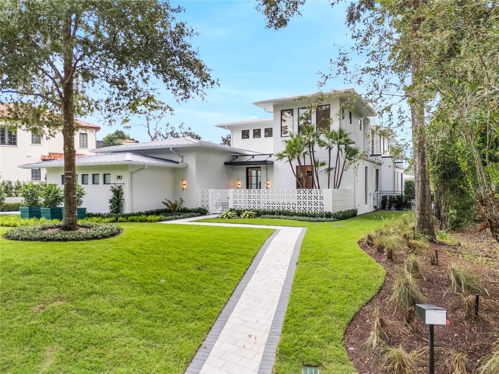 This gorgeous, new-construction FG Schaub custom home is the epitome of stunning contemporary design by architect, Michael Weinrich. As you enter this sprawling residence, with views of both Lake Sue and Lake Chelton you'll be greeted by exquisite tile work with brass inlays, wood floors, drop down ceiling, crown molding, wainscoting and natural light that pulls the outside living in. The first floor was meticulously designed with your Owner’s suite, an additional en suite bedroom with walk in closet, large laundry room with full size washer and dryer and an abundance of cabinet and counter space, an eye catching drop zone, elevator, storage room, kitchen and great room. The kitchen truly is a chef’s dream with Quartz countertops, spacious island, custom cabinetry with a satin brass inlay, and modern appliances including Tru refrigerator, freezer, a dual zone 150 bottle wine fridge, 60" Wolfe range with a custom range hood. The custom cabinetry continues into hidden butlers pantry complete with ice maker, microwave drawer, additional sink and Bosch dishwasher. The great room will be your hot spot for entertaining! Located off the kitchen, offering plenty of space for friends and family to gather with easy access to the pool area. Floor to ceiling Anderson windows, bar and an electric fireplace for that added touch of ambiance. Continuing into the Owner's suite you will find more expansive Anderson windows, private access to the outdoor living area, luxurious en-suite bathroom and custom closet. Feast your eyes on the 3x10 large format porcelain tile flooring, dual undermount glass sinks, 24K plated brushed gold fixtures, towel warmer, free standing soaking tub, large walk in shower and private water closet with smart toilet in your Owner’s bathroom. And the closet is a feature in itself with lighted LED rods, custom built ins, full length door mirrors and island. Access the second floor via the private elevator or staircase with a glass railing that leads to 3 additional bedrooms, all en-suite with custom tile work and walk in closets with built ins. You'll also find an additional laundry room with a stackable washer and dryer, linen closet, mechanical room and the activity space complete with wet bar and wrap around balcony with a custom glass railing offering sunsets over Lake Sue. Step outside to your own private oasis featuring a sparkling pool with 3 built in stools, sunshelf and spa, fire pit, and cabana with a full summer kitchen, roll away screens, half bathroom and an outdoor shower - ideal for weekend gatherings or relaxing evening meals poolside. Attention to detail carries out to the oversized 3-car garage which features epoxy flooring and a custom LED light design on the ceiling. While a hand crafted iron gate to the front courtyard gives a nod to Winter Parks favorite resident peacocks. A standing seam metal roof and lush landscaping adds the final aesthetic touch on this FG Schaub masterpiece. Welcome home to one of the most exceptional properties on the market!