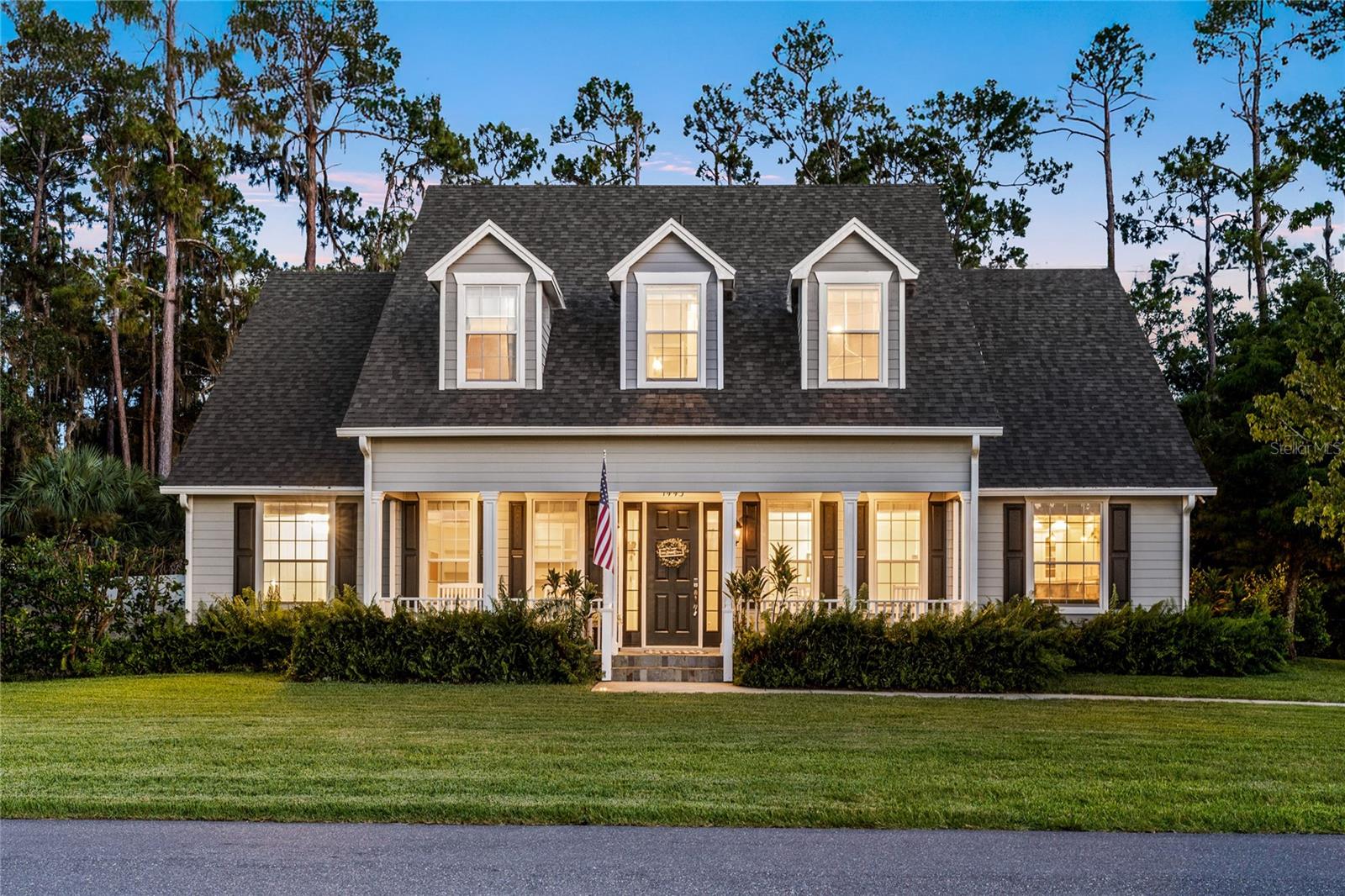 Welcome to this custom-built Cape Cod style estate, offering 5 bedrooms, 4 bathrooms, and a private resort-style pool—perfectly situated in the highly sought-after Stone Island community along the northern shore of Lake Monroe. This one-of-a-kind residence was originally constructed as the builder’s personal home, and it radiates craftsmanship, elegance, and timeless design at every turn.
From the moment you arrive, the home’s stately two-story colonial architecture captures attention with its classic Cape Cod charm. Grand columns, stone accents, shuttered windows, and a wide, inviting rocking chair front porch are nestled beneath a canopy of century-old grandfather oaks. The setting is both idyllic and exclusive, surrounded by natural beauty with private access to the St. Johns River and Intracoastal Waterway via the community’s boat ramp.
Inside, the home delivers a series of breathtaking spaces, starting with a soaring foyer and custom French doors that open into a private office featuring coffered ceilings, built-in shelving, and detailed millwork. Just beyond, the formal dining room offers a warm, intimate setting with hardwood flooring and a charming fireplace.
At the heart of the home lies a dramatic family room with 25-foot ceilings, engineered hardwood floors, a gas fireplace wrapped in stone, and a built-in theater system. The ambiance is enhanced by Juliet balconies above, double island-style ceiling fans, and a whole-home audio system that sets the tone for both entertaining and relaxation.
The chef’s kitchen is a dream come true—lined with white linen cabinetry featuring glass-accented displays, illuminated to highlight the rich contrast of ebony granite countertops. A large center island, two sinks, and stylish pendant lighting complete the elegant, functional space.
The thoughtfully designed layout includes dual staircases leading to separate upstairs wings, where you’ll find spacious secondary bedrooms and a versatile bonus room, ideal for a media area, game room, or private retreat.
The outdoor living space is equally impressive. Step into the screened-in backyard oasis featuring a resort-style heated saltwater pool with a grotto, cascading waterfall, LED lighting, and a covered cabana. A fully equipped summer kitchen makes entertaining a breeze, while the tranquil conservation views ensure privacy and peace. The oversized three-car garage is lined with built-in shelving, and a fenced compound with dual swing gates offers ample room to store your boat or trailer.
The property also features modern efficiency upgrades, including insulated glass windows and exterior doors, foam-insulated attic, private 160-foot-deep irrigation well, whole-home generator, and in-wall pest system. The home has also been recently enhanced with a new roof, as well as a new pool pump, and sprinkler well pump. A detached shed add to the home’s utility and convenience. Located in the vibrant, amenity-rich Stone Island community, residents enjoy access to a private boat dock, fishing, water skiing, tennis courts, horse stables, and neighborhood events throughout the year. Cruise the island by golf cart and experience one of Central Florida’s most unique and desirable waterfront lifestyles. This remarkable Cape Cod estate is truly one of a kind—blending refined living, thoughtful design, and unmatched location into a home you’ll cherish for years to come.