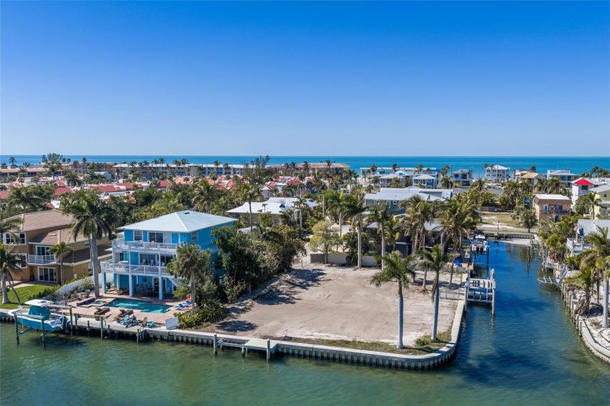 This waterfront corner lot offers a rare chance to build your custom coastal retreat on an expansive quarter-acre parcel just steps from the sands of the Gulf. With 196 feet of water frontage, tranquil views across the Intracoastal Waterway, and two existing boat lifts with protected dockage canal side, the property is perfectly suited for boating enthusiasts with direct access to open Gulf waters. Imagine designing a home that captures shimmering bay views, salty breezes, and effortless indoor/outdoor living, with ample space to add a pool and outdoor entertaining areas. The oversized corner footprint provides added flexibility for creative architectural design while maximizing privacy. Spend your mornings on the beach, your afternoons cruising the Gulf, and your evenings enjoying the laid-back island atmosphere just moments from charming shops and local dining. Large waterfront parcels this close to both boating and the beach are increasingly hard to find, making this an extraordinary canvas for your coastal vision.