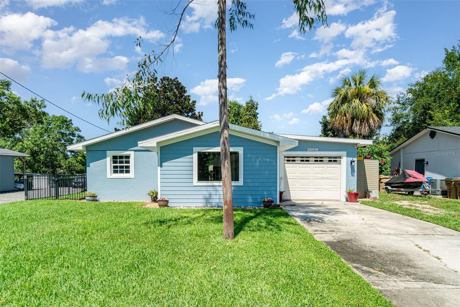 One or more photo(s) has been virtually staged. Welcome to 26619 Bimini Drive—a beautifully updated canal-front home in the highly desirable Lake Harris Shores, offering direct access to the Harris Chain of Lakes. With over 2,000 square feet of thoughtfully designed living space, this 3-bedroom, 3-bath residence blends comfort, efficiency, and Florida charm. Step inside to find an open-concept layout featuring new laminate floors, updated windows and doors (2024), and a flexible bonus room ideal for a home office or creative studio. The central kitchen offers stainless steel appliances, ample cabinetry, and a spacious walk-in "panic pantry" for extra storage. The split-bedroom floor plan offers privacy, and the primary suite boasts a walk-in closet and oversized bathroom with a jetted tub/shower combo. Major system upgrades have already been taken care of, including a hybrid heat pump water heater, which not only saves on energy costs but also helps cool the surrounding space—making your garage or utility area feel noticeably cooler. Additional improvements include new siding, insulation, windows, and doors (2024), a new aluminum seawall (2020), covered boathouse and lift (2021), Wi-Fi-enabled sprinkler controller (2025), and a screened rear patio (2024) perfect for relaxing as the sun sets over the water. Outside, the fenced backyard is irrigated with lake water for low-cost, eco-friendly landscaping. The home also includes access to a private community boat ramp, clubhouse, and beach—all covered by a low $700 annual HOA that includes water. Located just minutes from downtown Tavares and Mount Dora and under 45 minutes to Orlando, this is your chance to enjoy the Florida lake lifestyle—updated, efficient, and ready for you. Vacant and easy to show. Schedule your private tour today.
*Dock lift capacity: 5,000 lbs.
*Exterior siding: Hardy (concrete), not wood.
*Garage: Screen covers the garage door.
*Dock dimensions for interior slip space: 28’ x 10’.