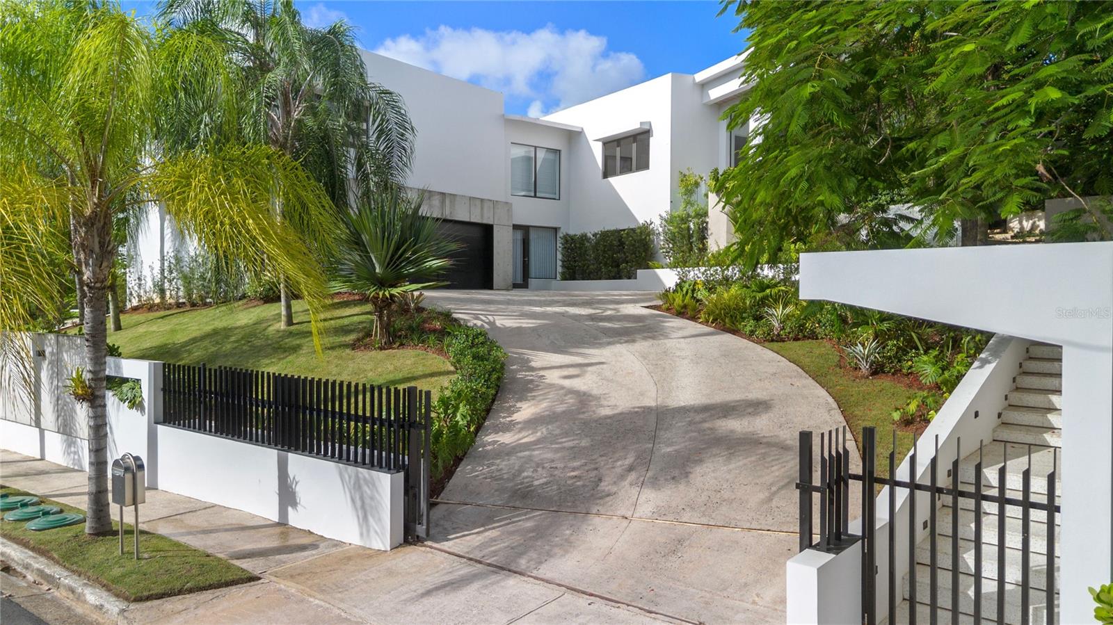 Step into a beautifully reimagined residence in one of San Juan’s most desirable gated communities. This 6 bedroom, 6 full and 2 half bathroom home spans approximately 4,400 square feet, offering a perfect balance of luxury, comfort, and everyday functionality.
A lush, manicured entrance sets the tone for the refined interior, where soaring ceilings, abundant natural light, and stunning marble floors create a welcoming and elegant atmosphere. Spacious proportions and thoughtful finishes define every corner of the home, making it ideal for both relaxed living and entertaining.
The heart of the home is a stylish kitchen equipped with top of the line appliances, custom cabinetry, and a large island that invites friends and family to gather. The open concept living area flows effortlessly into the outdoors, where a beautifully designed patio awaits. This serene outdoor retreat features a large covered terrace, sparkling pool, and expansive yard that feels like an extension of the living space, perfect for everything from quiet morning coffees to festive weekend gatherings.
An outdoor kitchen with a BBQ grill, a half basketball court, and generous green space provide plenty of room to play, unwind, and enjoy time with loved ones. Whether you're hosting or simply relaxing, the outdoor areas are designed to elevate your lifestyle.
A spacious garage and extended driveway provide room for multiple vehicles, while additional storage keeps things organized and convenient.
Set in a secure, family friendly community with 24/7 security, this home also gives you access to resort style amenities including tennis courts, basketball courts, soccer fields, playgrounds, parks, and a clubhouse. Just minutes from top private schools and recreational hubs, this property is more than a home, it’s a lifestyle.