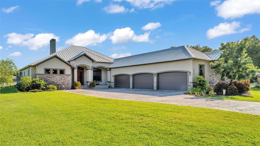 Discover the epitome of luxury living in this stunning custom-built home, completed in 2016 by LK&T Construction. Situated on over an acre of beautifully manicured land, this 5-bedroom, 2.5-bathroom residence features an office and an impressive 6-car garage, offering ample space for both comfort and convenience. Upon entering, you are greeted by a flowing open concept layout enhanced by exquisite engineered hardwood flooring and elegant crown molding throughout. This inviting design promotes both functionality and style, making it an ideal space for entertaining guests or enjoying quiet family moments. Step into the heart of the home: a spacious kitchen equipped with top-of-the-line Thermador stainless steel appliances, including a gas-burning stove. The space boasts a stunning backsplash, luxurious granite countertops, abundant cabinetry, and generous counter space, complemented by a walk-in pantry and a cozy eat-in nook—perfect for casual dining. The expansive living room features soaring high ceilings, a charming wood-burning fireplace, and custom built-in shelving, creating a warm and welcoming atmosphere perfect for relaxation and gatherings. Retreat to the sumptuous primary bedroom, offering a private oasis complete with an ensuite bathroom that highlights dual walk-in closets, separate vanities, a standalone soaking tub, and an expansive tiled walk-in shower—a perfect escape at the end of the day. On the opposite side of the home, you will find two well-appointed bedrooms that share a full-size bathroom, providing privacy for family or guests. Two additional bedrooms, equally spacious and also featuring walk-in closets, offer comfort and style for all occupants. A separate space at the entrance of the home is perfect for a home office or game room, providing flexibility for your lifestyle needs. Enjoy outdoor living at its finest with a large screened-in pavered patio that overlooks a tranquil koi pond—an idyllic setting for every season, whether you're hosting gatherings or enjoying quiet moments in nature. This home is equipped with a whole-home Generac generator and a water softener for added comfort and peace of mind. The durable metal roof enhances both aesthetics and durability, ensuring long-lasting quality. Conveniently located with quick access to I-4, shopping, and dining, this estate offers the perfect balance of privacy and accessibility. Don't miss out on this exceptional opportunity to own a custom-built estate that combines luxury, elegance, and modern living. Schedule your private tour today and experience all that this remarkable property has to offer!