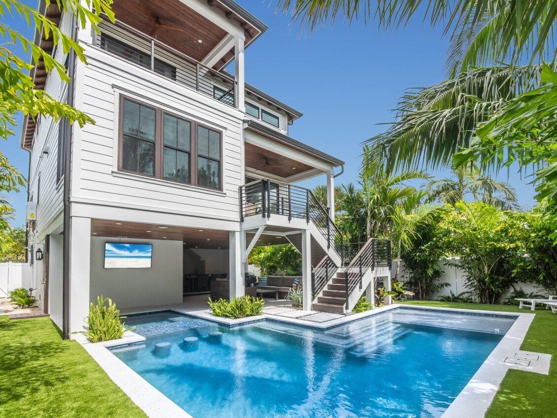 Welcome to Luxe Island Escape, an exceptional 4-bedroom, 4.5-bath coastal retreat nestled in the tranquil heart of Anna Maria Island. This captivating residence is offered fully turnkey furnished—ready for you and your family to immediately embrace the island lifestyle.
Designed with thoughtful design and coastal sophistication, the home is surrounded by lush tropical landscaping and features a private heated pool, spa, and an expansive rooftop deck offering sweeping views of both the Gulf of Mexico and Tampa Bay.
Inside, a bright, open-concept floor plan awaits, enhanced by soaring ceilings and custom contemporary finishes throughout. The main living level showcases a designer kitchen outfitted with sleek stainless-steel appliances, a striking island, and abundant space for entertaining. The dining area and great room flow seamlessly onto a covered deck, welcoming in the sea breeze and natural light.
Also on the main floor are two tranquil guest suites with private baths, offering comfort and privacy for visiting family and friends. Upstairs, the serene primary suite opens to a private deck—an ideal retreat for peaceful mornings and quiet evenings and an extra surprise space for an office or sitting area. Make sure you ascend to the rooftop deck for panoramic island views and breathtaking sunsets.
Ideally located just a 2-minute walk from the sparkling waters of Tampa Bay and only 5 minutes from the pristine shores of Anna Maria Island’s iconic Bean Point, this home offers the ultimate blend of tranquility, beauty, and fun. Currently operating as a busy vacation rental property, Luxe Island Escape presents a rare opportunity for full-time living or a luxurious coastal escape vacation rental. Don't miss your chance—book your private showing today.
