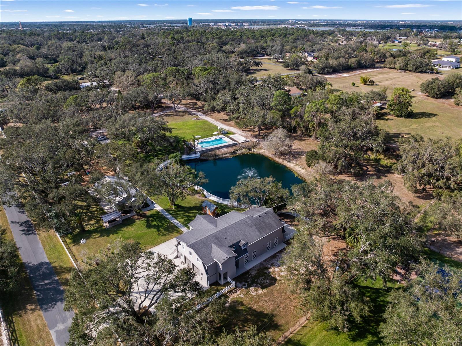 One or more photo(s) has been virtually staged. Discover the Ultimate Sanctuary in Fox Creek II!
Tucked away on a private drive, this breathtaking 5-acre estate—one of the last remaining in Sarasota where you can build your dream home—offers endless opportunities. Whether you’re looking for a private family compound, a horse lover’s paradise, a premier event venue, or the perfect place to run your business from home, this property has it all. Enclosed by lush trees and a solid perimeter wall, this magnificent estate is a true private oasis. Enjoy the oversized outdoor pool, explore the serene boating pond with its enchanting water feature, or let the little ones play in their own private playground. The entertainment hall, complete with a full kitchen, is the perfect space for unforgettable gatherings with family and friends.
Currently an income-producing property, this estate has hosted private events, retreats, and gatherings, generating revenue as a sought-after venue. With endless possibilities, it can continue to serve as a profitable investment or be transformed into your dream residence.
Enjoy the perfect blend of rural serenity and modern convenience. In just 5 minutes, you can access the interstate, opening a world of possibilities. The vibrant University Town Center (UTC) area—home to over 250 stores, top-tier restaurants, and entertainment venues—is only 12 minutes away. UTC also features Nathan Benderson Park, a world-class destination for outdoor recreation and international rowing events. Just 20 minutes away, Downtown Sarasota invites you to explore its rich arts scene, waterfront parks, and award-winning dining and only 30 minutes to the award winning Siesta Key Beach.
This extraordinary 3-bedroom, 2-bathroom & space for optional 4th bedroom and 3rd bath with elevator estate isn’t just a home—it’s a private retreat where every day feels like a vacation. Whether you choose to enjoy its existing beauty, create the ultimate family compound, horse property, host spectacular events, or design and build your dream residence, the possibilities are truly endless.
Don’t miss this rare opportunity—schedule your private showing today!