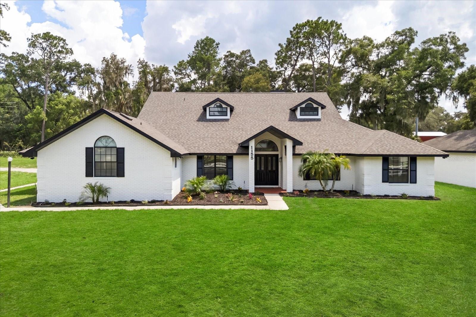 Step into unparalleled elegance with this exceptional estate, gracefully sited on 2.5 meticulously maintained acres behind a private gate. Perfectly located just 6 minutes from I-4, 5 minutes from the charm of historic Downtown DeLand, and only 40 minutes from both the shores of New Smyrna Beach and Downtown Orlando—this location offers the ideal balance of tranquility and connectivity. From the moment you enter through the grand double doors, you are greeted by exquisite luxury everywhere. No detail has been spared in the process of renovating and reimagining this home. This expansive home features SIX BEDROOMS PLUS AN OFFICE, thoughtfully designed for both comfort and versatility. The heart of the home is the impressive great room, where soaring vaulted ceilings frame a striking stone fireplace, setting the tone for stylish gatherings or intimate evenings. There is luxury vinyl plank flooring throughout, no carpet can be found in this home. The chef’s kitchen is a masterpiece, fully updated with premium KitchenAid stainless steel appliances, custom cabinetry, and not one—but two quartz-topped islands, with a breathtaking tile backsplash, providing abundant space for meal prep, entertaining, or casual dining.
Retreat to the grand primary suite, a true sanctuary that offers ample space for a sitting area or nursery, all bathed in natural light from a bay window overlooking the sprawling grounds. The ensuite bath rivals a five-star spa, complete with dual vanities, a garden tub framed by another beautiful bay window, an oversized walk-in shower with custom tilework, and elegant finishes throughout. The west wing of the home includes two additional bedrooms and a tastefully renovated full bathroom, while the east wing offers three more bedrooms and two stylishly updated bathrooms—one with direct access to the pool, ideal for seamless indoor-outdoor living. All bathrooms have quartz countertops and custom tilework. Designed for multigenerational living or families of all sizes, this estate is also a true outdoor paradise. A newly resurfaced screen-enclosed pool anchors the outdoor experience, complemented by two expansive covered living areas perfect for relaxing or entertaining. The custom-built summer kitchen boasts a built-in grill, separate burner, sink, and mini fridge—an entertainer’s dream. For the automobile enthusiast, the estate includes a massive driveway and four-car garage. The fourth car garage is 800 sq ft with limitless potential. Whether used for boat or RV storage, a workshop, guest quarters, or even a horse barn, the space invites you to imagine and create. This rare offering seamlessly blends luxury, functionality, and endless opportunity. This home is zoned RA (rural agriculture) and does allow for the keeping of animals including horses for personal use. Homes of this caliber are few and far between—schedule your private showing today.