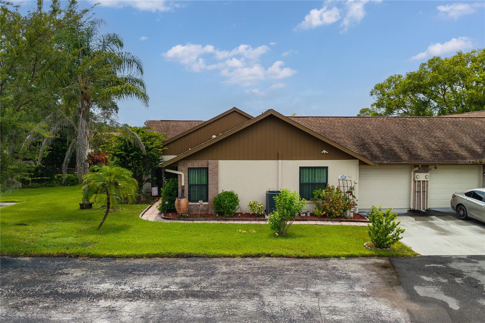 Discover the perfect blend of comfort and convenience in this well-maintained and move-in-ready 2-bedroom, 2-bathroom, 1-car garage, villa-style single-family home located in the quiet Ruxton Village in Tall Pines at River Ridge 55+ community in New Port Richey. This residence offers true maintenance-free living, allowing you to spend your time enjoying all the things you love. Step inside to an inviting open-concept living and dining area, where abundant natural light streams in through the skylight, and hurricane-impact windows, which were installed in 2022. This home is packed with recent upgrades for your peace of mind, including a new HVAC system installed in 2024, a tankless water heater, and a water softener installed in 2022. The entire home features elegant tile floors, making for easy cleaning and a sleek, modern look. The spacious kitchen is complete with granite countertops, a breakfast bar, and ample cabinet space. Just off the main living area, a versatile den provides the perfect space for a home office, a creative crafts area, or a cozy reading nook. Relax and unwind in one of two peaceful screened-in outdoor spaces: a charming front porch or a private rear atrium — ideal for enjoying your morning coffee or an evening breeze. The home also includes a convenient 1-car garage with a garage door screen, allowing protection from insects while you work on a project or simply take in the fresh air. The primary bedroom has plenty of room to accommodate a king-sized bed and features an ensuite bathroom equipped with a skylight and a granite-topped vanity. The location is a commuter's dream, with quick access to State Road 589/Suncoast Parkway, putting Tampa and Tampa International Airport just a short drive away. For your daily needs, you're minutes from Ridge Road and Little Road, offering a fantastic selection of shopping and dining options, along with nearby medical facilities. Experience the ease of low-maintenance living and the joy of a move-in-ready home. Don't miss your chance to see this gem! Call today to schedule your private showing!