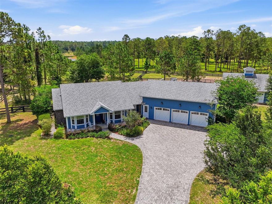 Unrivaled sophistication meets the ultimate equestrian lifestyle in the premier enclave of Lakewood Ranches. Beyond your own private security gate, a grand paver driveway introduces a striking custom-built estate situated on over 3.5 pristine, fully fenced acres. Offering panoramic views of rolling pastures and a tranquil lake, this luxury property delivers complete seclusion with no direct rear neighbors.
The main residence spans nearly 2,800 square feet of impeccably designed living space, defined by rich hardwood flooring, dramatic exposed wood ceiling beams, and an effortless open-concept flow. The culinary kitchen serves as the heart of the home, showcasing custom light cabinetry, premium stone countertops, a massive social island, professional stainless appliances including a gas range, and an expansive walk-in pantry—perfectly positioning you to entertain while overlooking the grand dining and living spaces.
Retreat to the primary wing, a true sanctuary featuring soaring vaulted ceilings, expansive windows showcasing the grounds, and direct access to the private pool and spa. The en-suite features an opulent walk-in shower, double vanities, and spacious walk-in closet. Designed with a smart split-bedroom layout, the main level features two additional guest bedrooms and a private study, while upstairs reveals a massive, flexible bonus suite ideal for an executive office, library, or private guest retreat.
Outside, a world-class equestrian setup awaits: a premium, center-aisle 3-stall barn complete with rubber matting, individual stall fans, washing station, a finished tack room with a utility sink and half bathroom, a dedicated feed room, and a high-volume hay storage room. Train on your private riding ring, all framed by elegant grazing pastures. An oversized detached garage offers the ultimate showroom with massive ceiling heights for watercraft, ATVs, tractors, or collector vehicles. Positioned perfectly for the active equestrian, this estate places you under 90 minutes from Ocala's world-renowned World Equestrian Center. Locally, you are under 25 minutes from premier training facilities like Rocking Horse Stables, and immediate access to miles of protected, scenic riding trails at Seminole State Forest. Backed by a robust local infrastructure of specialized equine vets and premium suppliers right here in Lake County, this property offers a seamless, turnkey lifestyle for horse and rider alike. A true masterpiece of luxury acreage! Elevate your lifestyle and secure your private tour of this masterfully designed equestrian estate today!